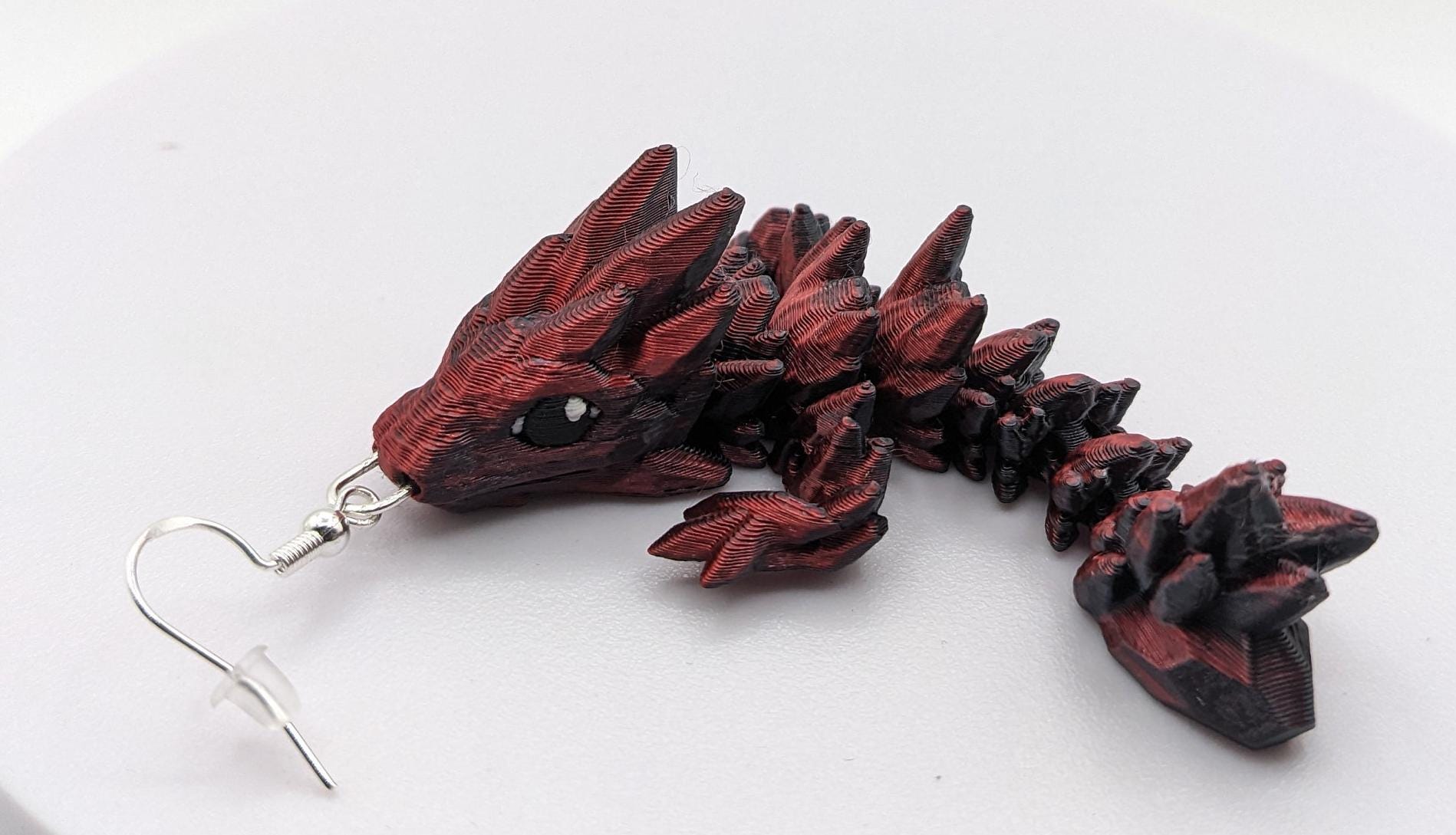 Handcrafted with exquisite detail, these enchanting earrings are the perfect blend of fantasy and elegance, designed to add a touch of whimsy to any outfit. The baby dragon is articulated and moveable.