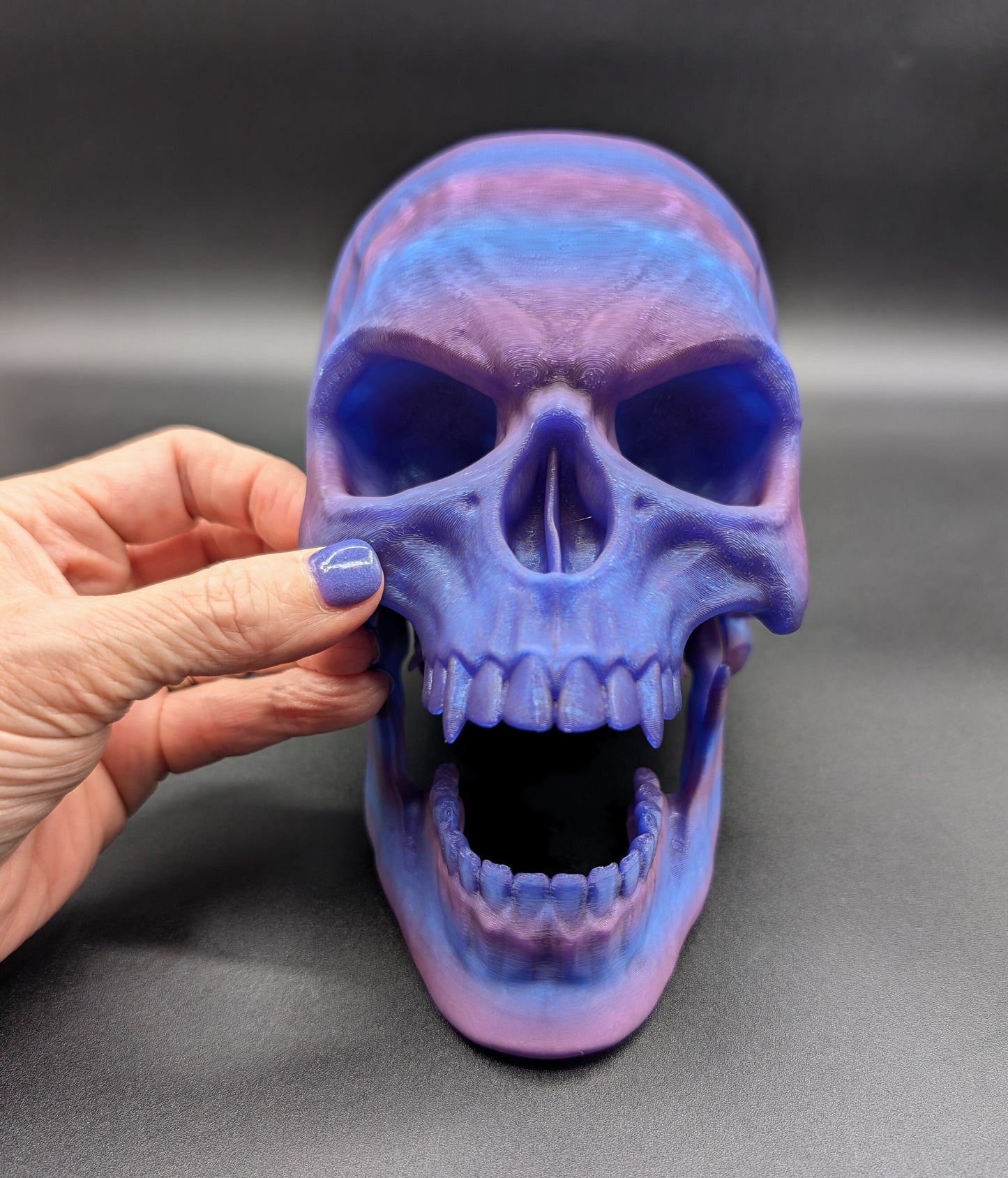 Introducing our Articulated Halloween Vampire Human Skull, the perfect addition to your Halloween decor or gothic collection. This intricately designed skull is a fun and interactive item, thanks to its fully articulated jaw. Multiple colors offered!