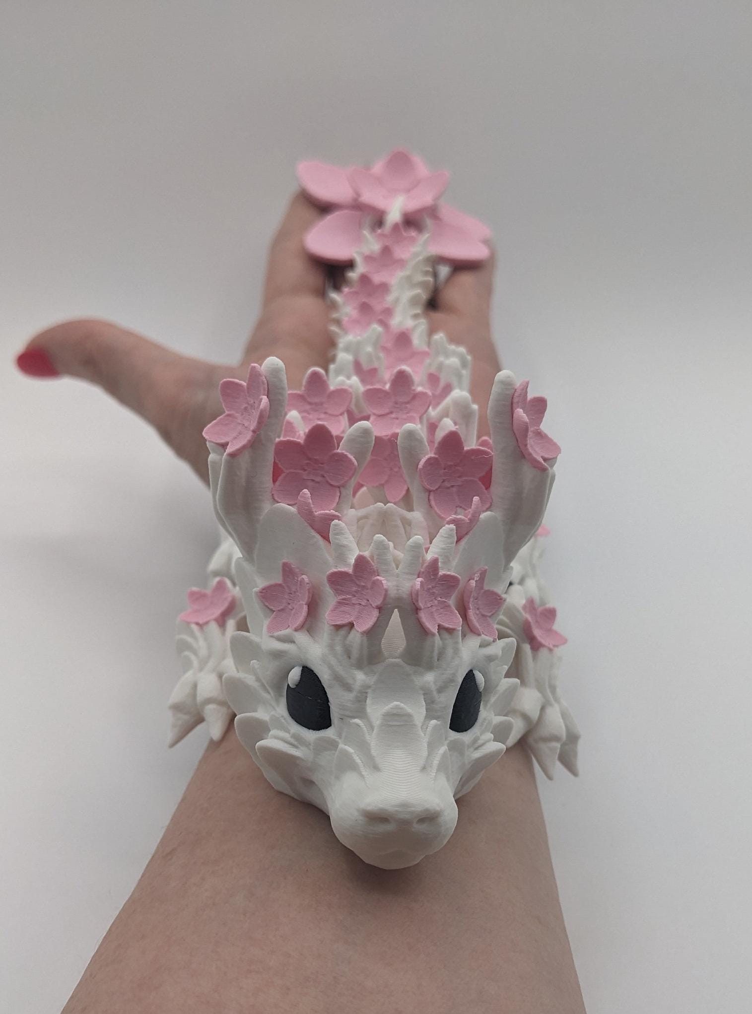 Introducing our Beautiful Articulated Baby Blossom Dragon Fidget Toy, a charming and playful addition to your collection.