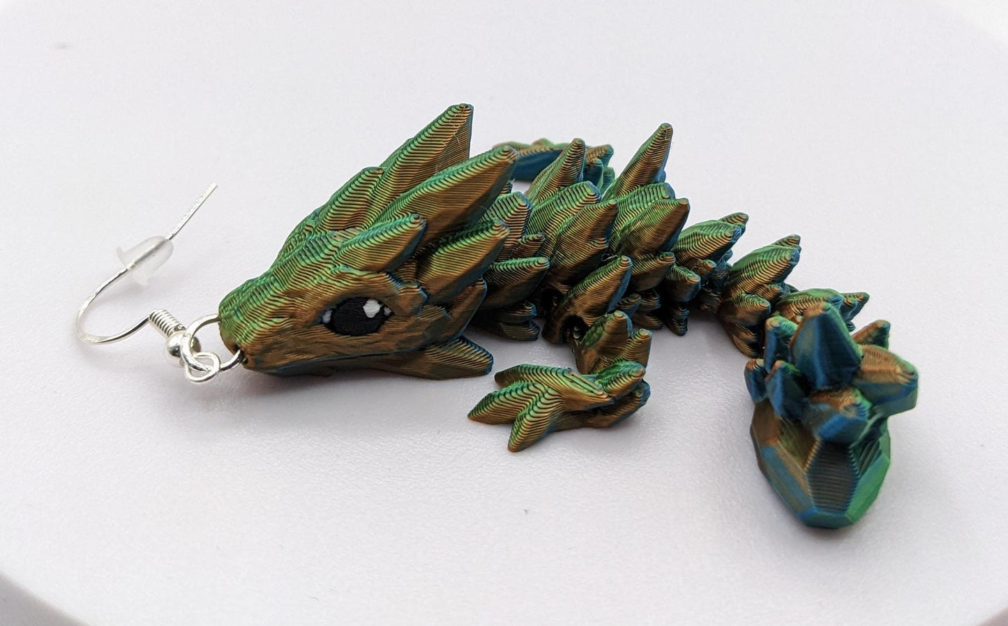 Handcrafted with exquisite detail, these enchanting earrings are the perfect blend of fantasy and elegance, designed to add a touch of whimsy to any outfit. The baby dragon is articulated and moveable.