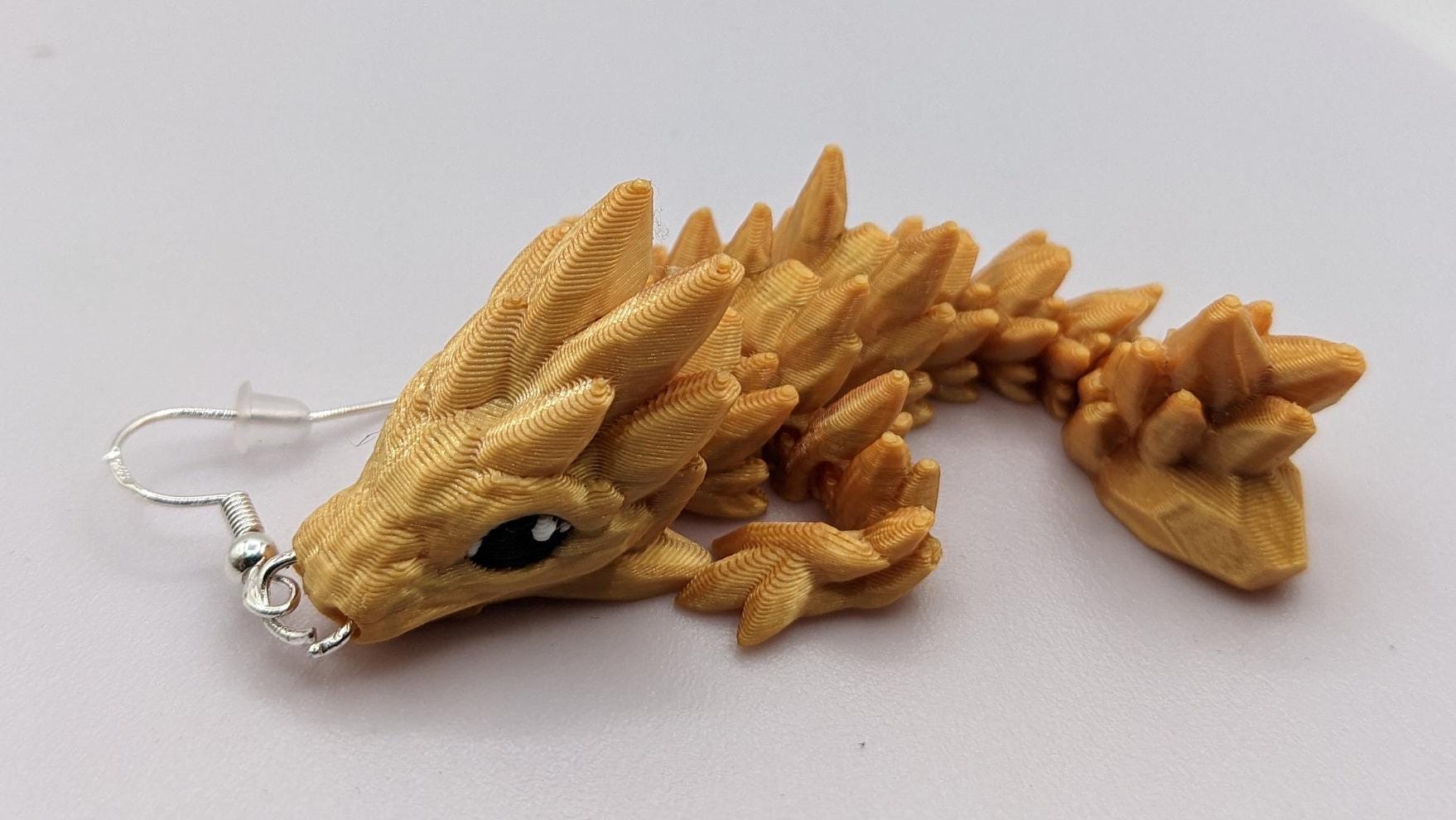 Handcrafted with exquisite detail, these enchanting earrings are the perfect blend of fantasy and elegance, designed to add a touch of whimsy to any outfit. The baby dragon is articulated and moveable.