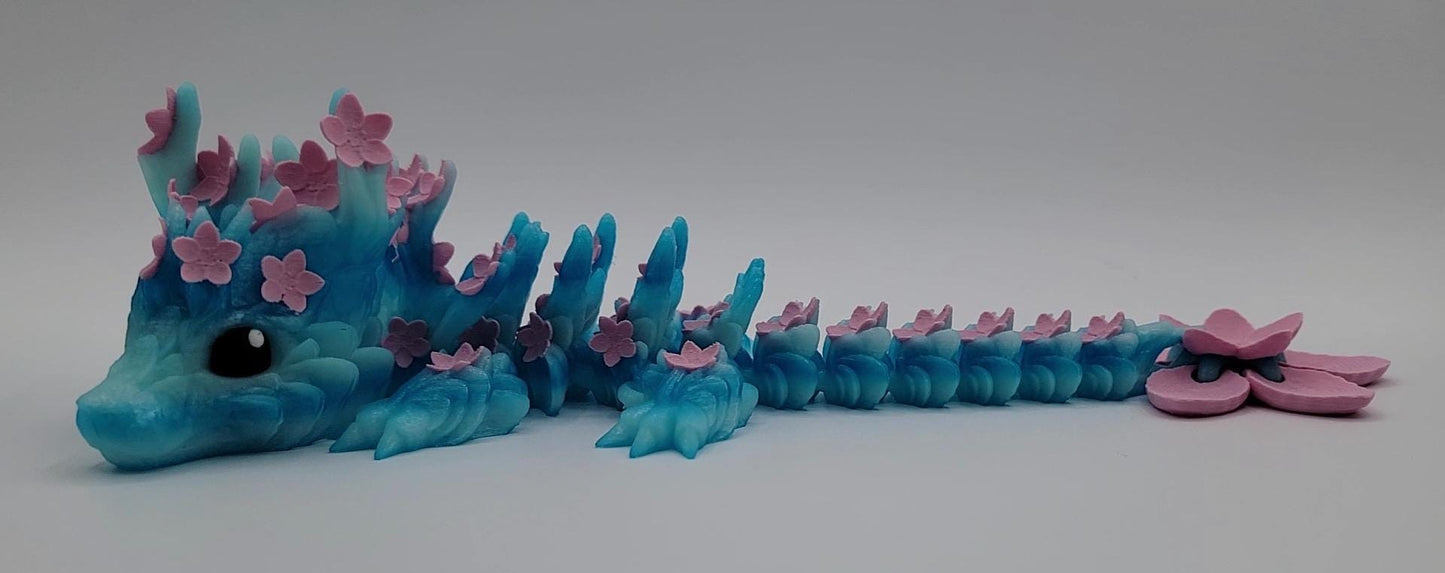 Introducing our Beautiful Articulated Baby Blossom Dragon Fidget Toy, a charming and playful addition to your collection.
