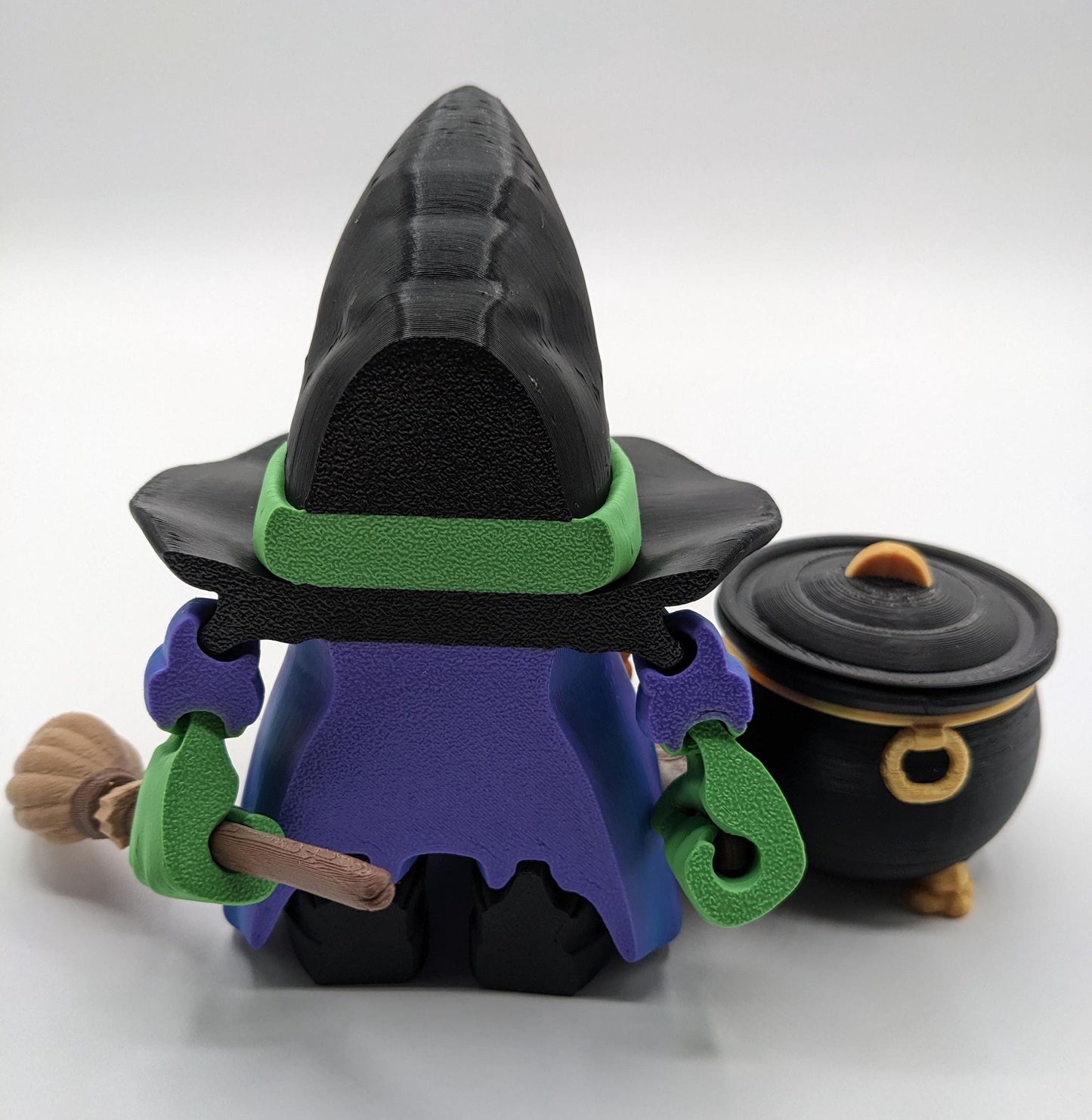 Meet our Articulated Halloween Witch Gnome with Cauldron, Broom, & Spoon! This delightful gnome brings whimsical magic to your seasonal decor. Perfect for Halloween enthusiasts and collectors, this piece is sure to add a playful charm to any setting.