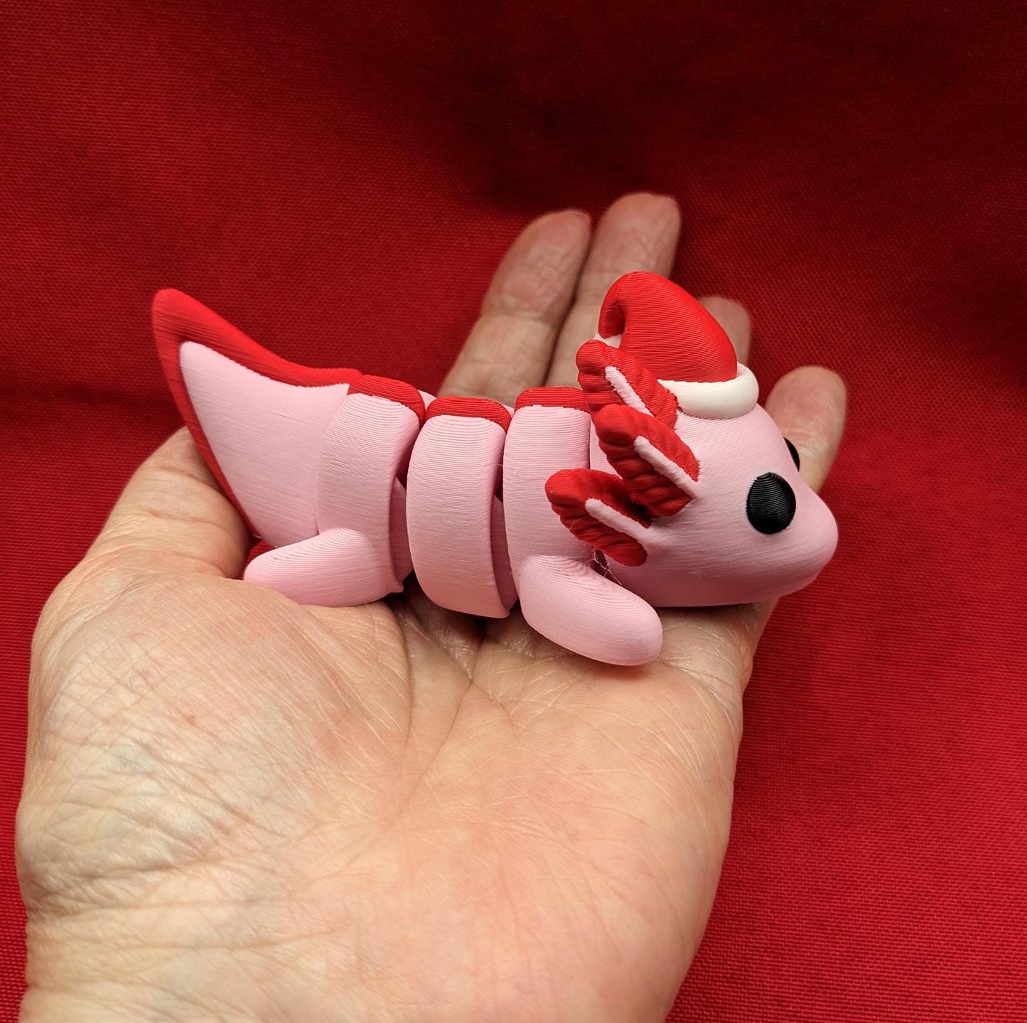 Celebrate the joy of the season with our Articulated Winter Christmas Axolotl Fidget Toy with a cute little Santa hat. This adorable and festive axolotl is perfect for spreading holiday cheer and providing endless fun.