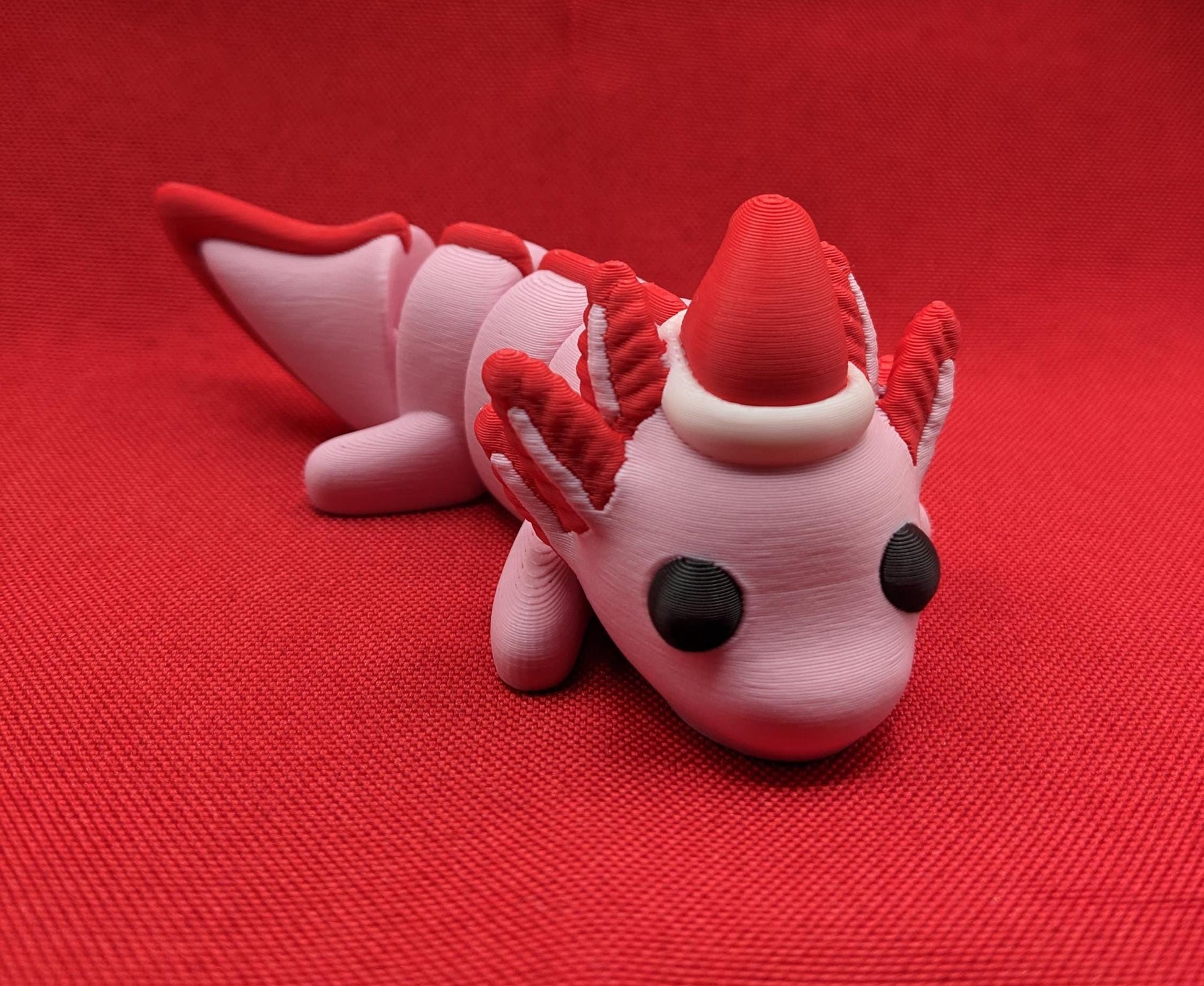 Celebrate the joy of the season with our Articulated Winter Christmas Axolotl Fidget Toy with a cute little Santa hat. This adorable and festive axolotl is perfect for spreading holiday cheer and providing endless fun.