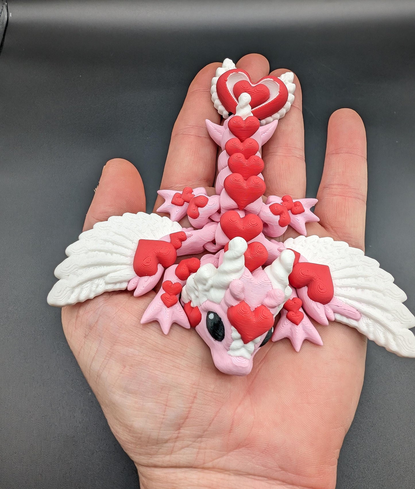 Discover the magic of our Valentine Heart Dragon! This enchanting articulating dragon not only graces your bookshelf with whimsy but also makes for a heartfelt and unforgettable Valentine's Day gift.
