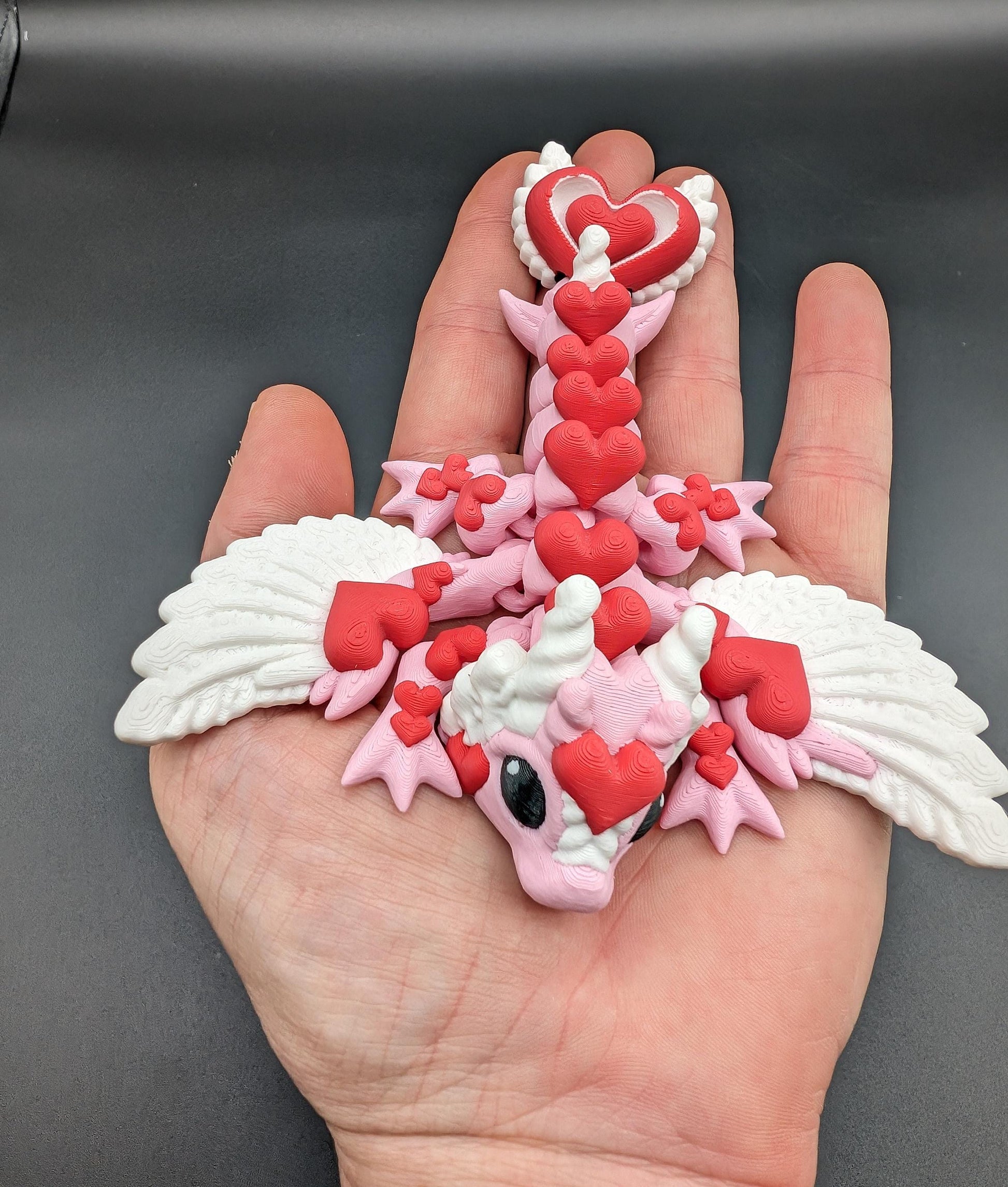 Discover the magic of our Valentine Heart Dragon! This enchanting articulating dragon not only graces your bookshelf with whimsy but also makes for a heartfelt and unforgettable Valentine's Day gift.