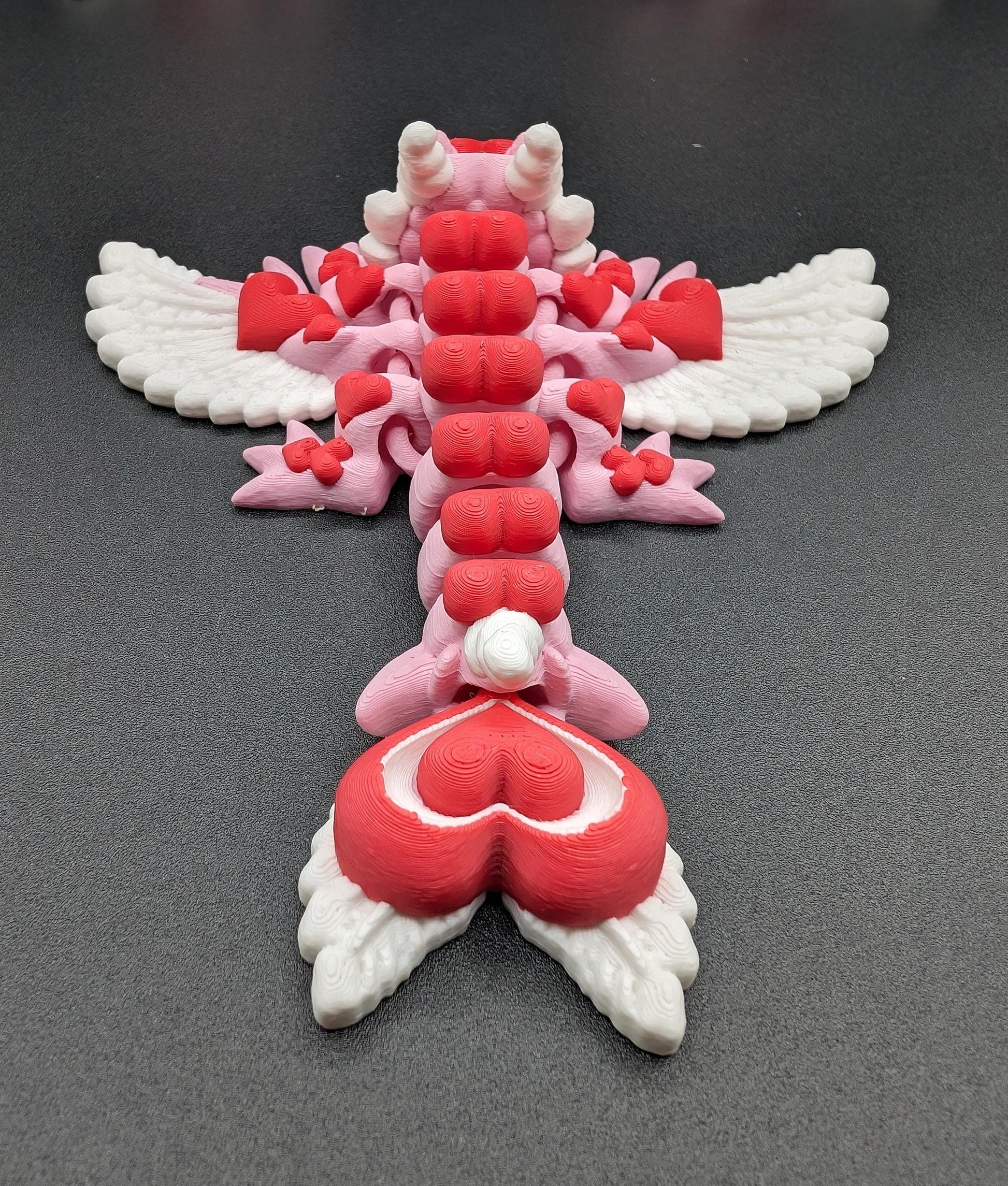 Discover the magic of our Valentine Heart Dragon! This enchanting articulating dragon not only graces your bookshelf with whimsy but also makes for a heartfelt and unforgettable Valentine's Day gift.