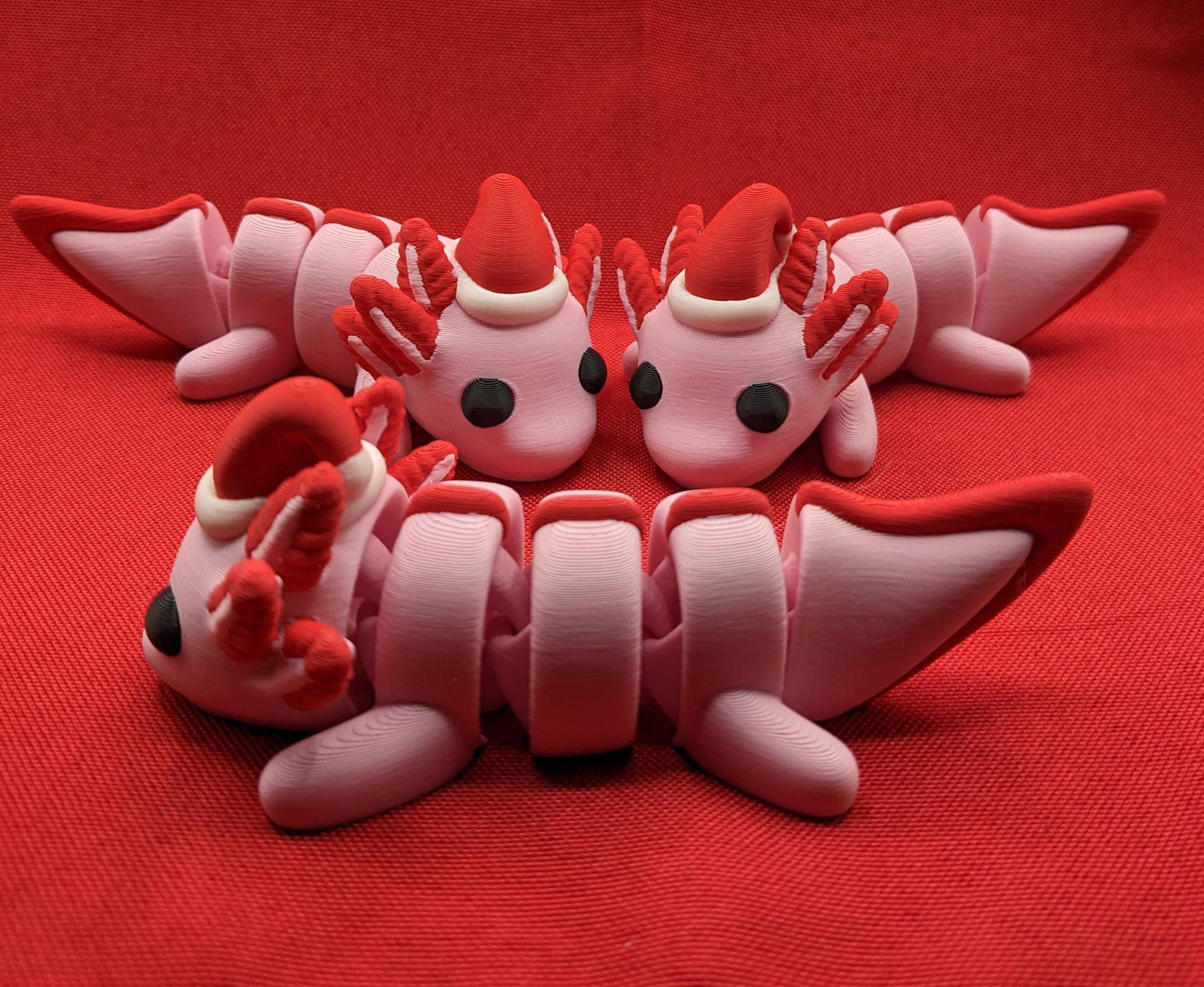 Celebrate the joy of the season with our Articulated Winter Christmas Axolotl Fidget Toy with a cute little Santa hat. This adorable and festive axolotl is perfect for spreading holiday cheer and providing endless fun.