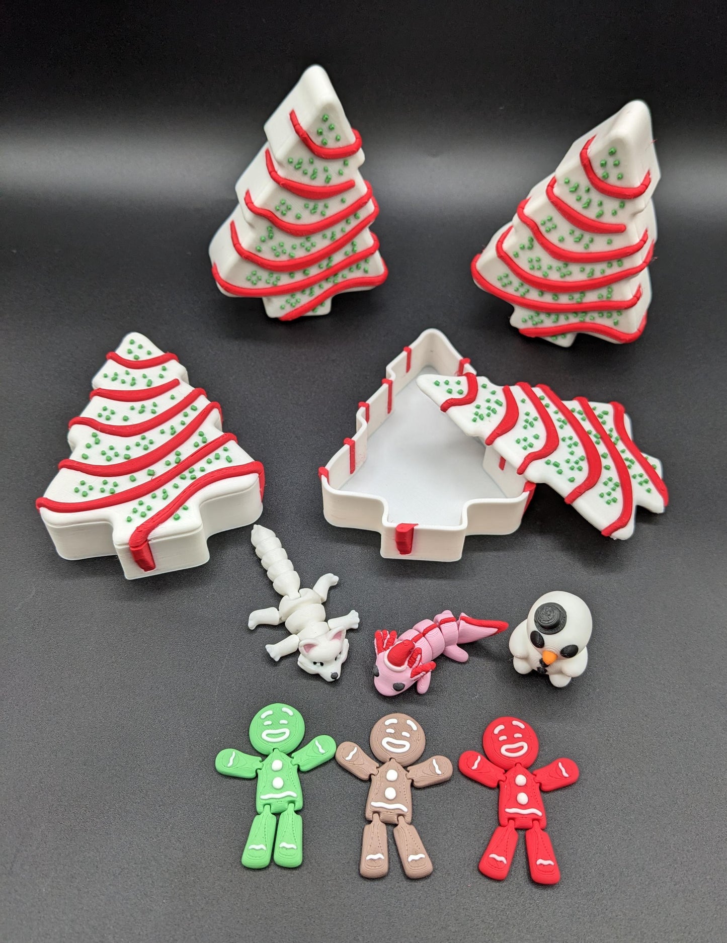 Add a delightful touch of holiday magic to your decor or gift-giving with our Yummy Christmas Tree Cake Container with 6 Mini Figures! This cute container is designed to look like a festive Christmas tree cake with 6 adorable mini figures!