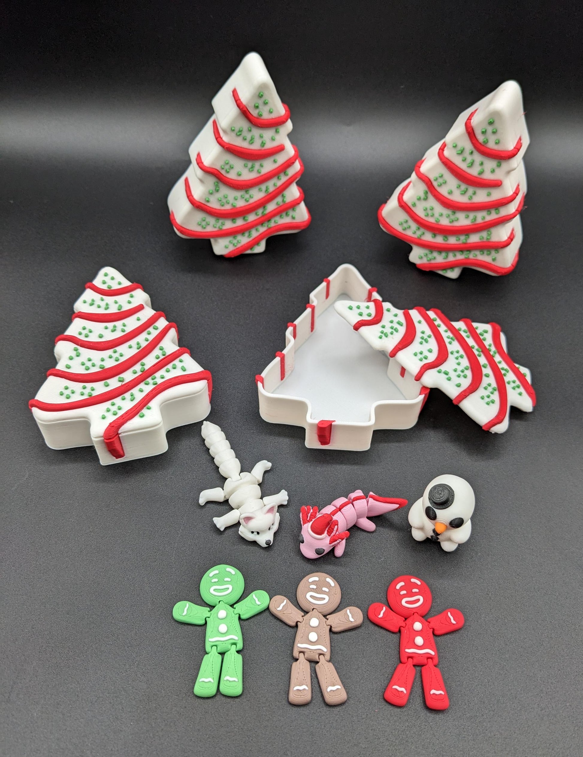 Add a delightful touch of holiday magic to your decor or gift-giving with our Yummy Christmas Tree Cake Container with 6 Mini Figures! This cute container is designed to look like a festive Christmas tree cake with 6 adorable mini figures!