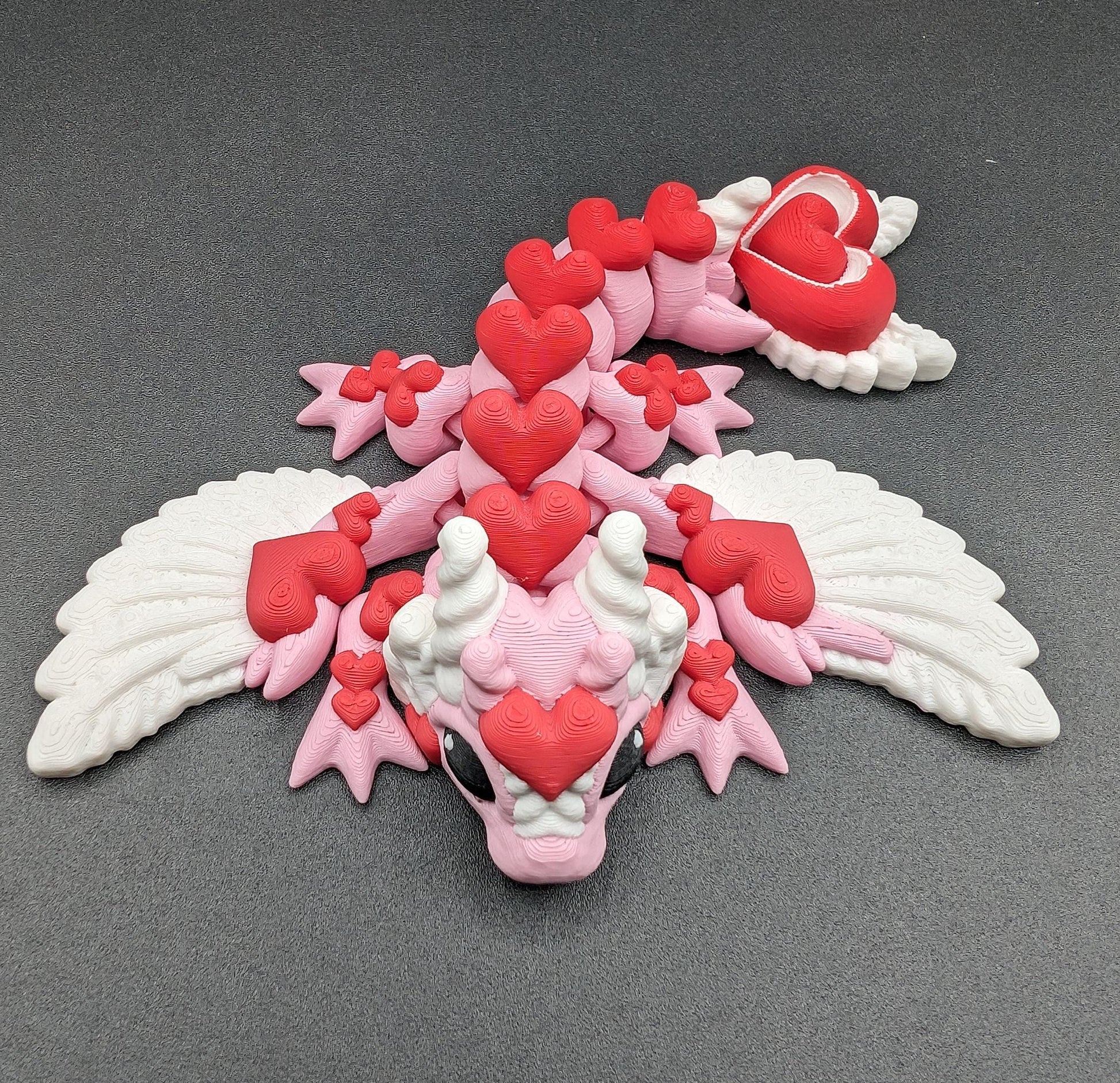 Discover the magic of our Valentine Heart Dragon! This enchanting articulating dragon not only graces your bookshelf with whimsy but also makes for a heartfelt and unforgettable Valentine's Day gift.