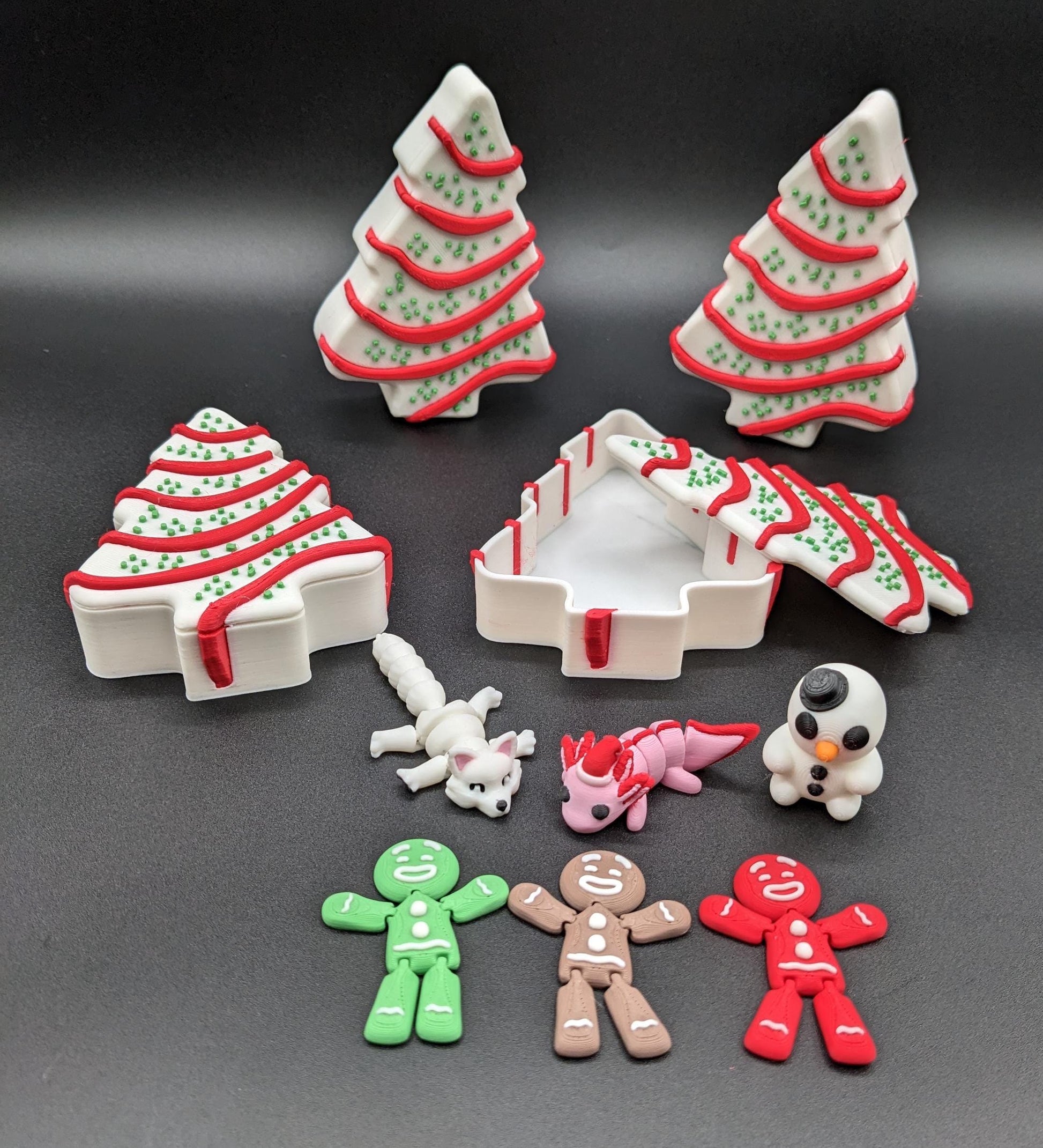 Add a delightful touch of holiday magic to your decor or gift-giving with our Yummy Christmas Tree Cake Container with 6 Mini Figures! This cute container is designed to look like a festive Christmas tree cake with 6 adorable mini figures!