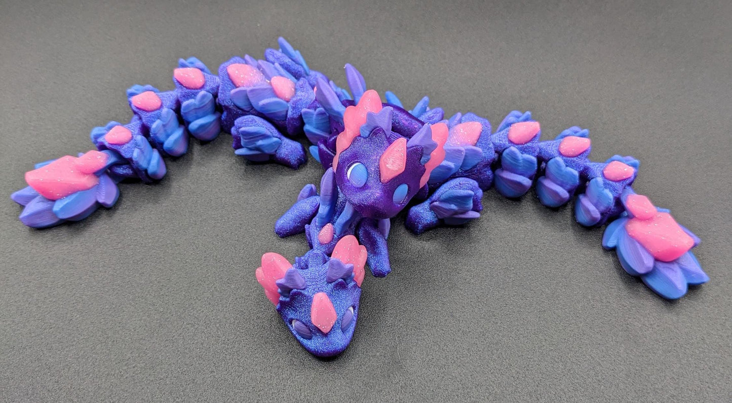 Whether you’re looking for a stress-relief toy, a whimsical desk companion, or a one-of-a-kind gift, Baby RubiKuro is here to charm kids, teens, & adults alike. Colorful, durable, & irresistibly adorable, our baby dragon is the perfect companion.