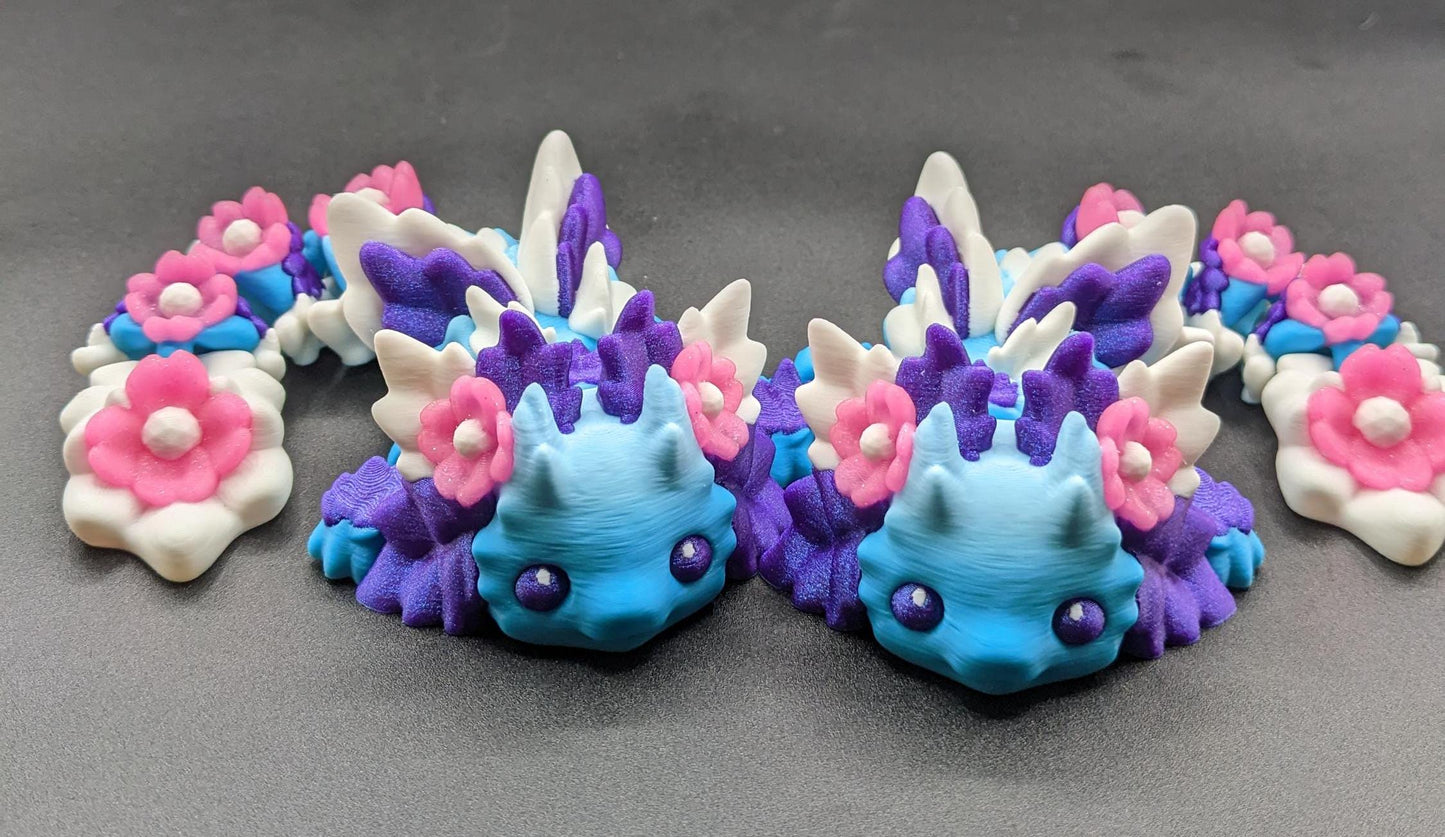 Let the Adorable Baby Kosha Axolotl Flower Dragon bring joy, relaxation, & a touch of enchantment into your life! Whether you’re treating yourself or someone special, this charming fidget toy is a delightful combination of fantasy & creativity.