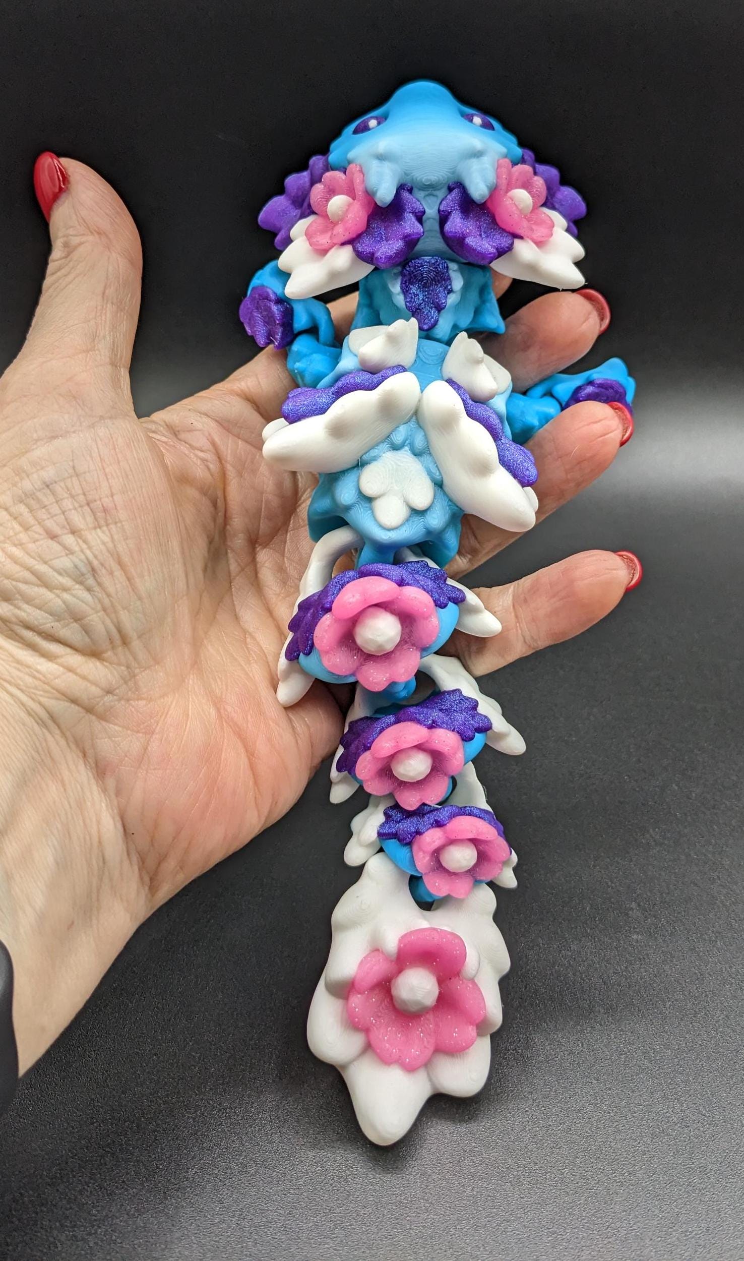 Let the Adorable Baby Kosha Axolotl Flower Dragon bring joy, relaxation, & a touch of enchantment into your life! Whether you’re treating yourself or someone special, this charming fidget toy is a delightful combination of fantasy & creativity.