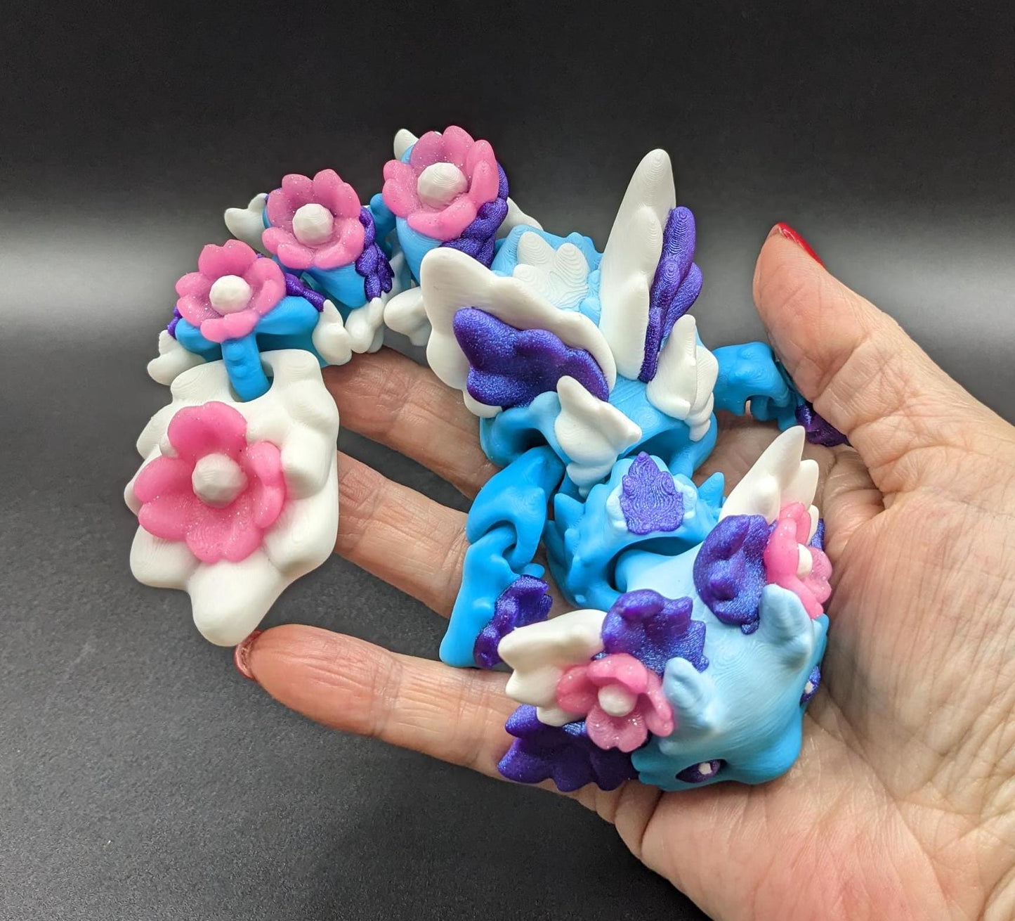 Let the Adorable Baby Kosha Axolotl Flower Dragon bring joy, relaxation, & a touch of enchantment into your life! Whether you’re treating yourself or someone special, this charming fidget toy is a delightful combination of fantasy & creativity.