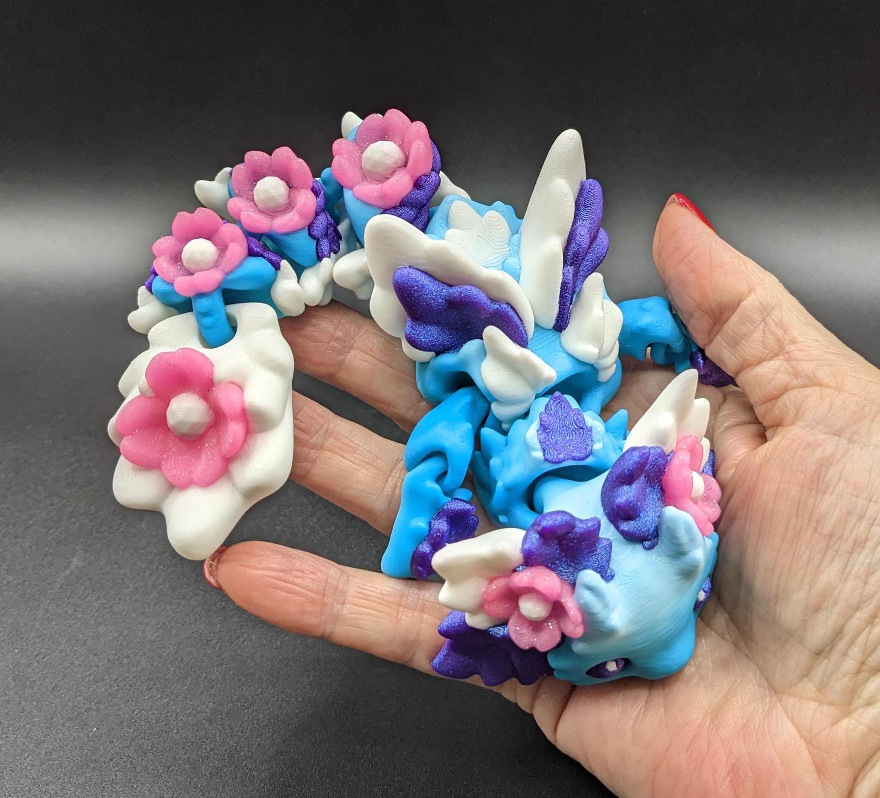 Let the Adorable Baby Kosha Axolotl Flower Dragon bring joy, relaxation, & a touch of enchantment into your life! Whether you’re treating yourself or someone special, this charming fidget toy is a delightful combination of fantasy & creativity.
