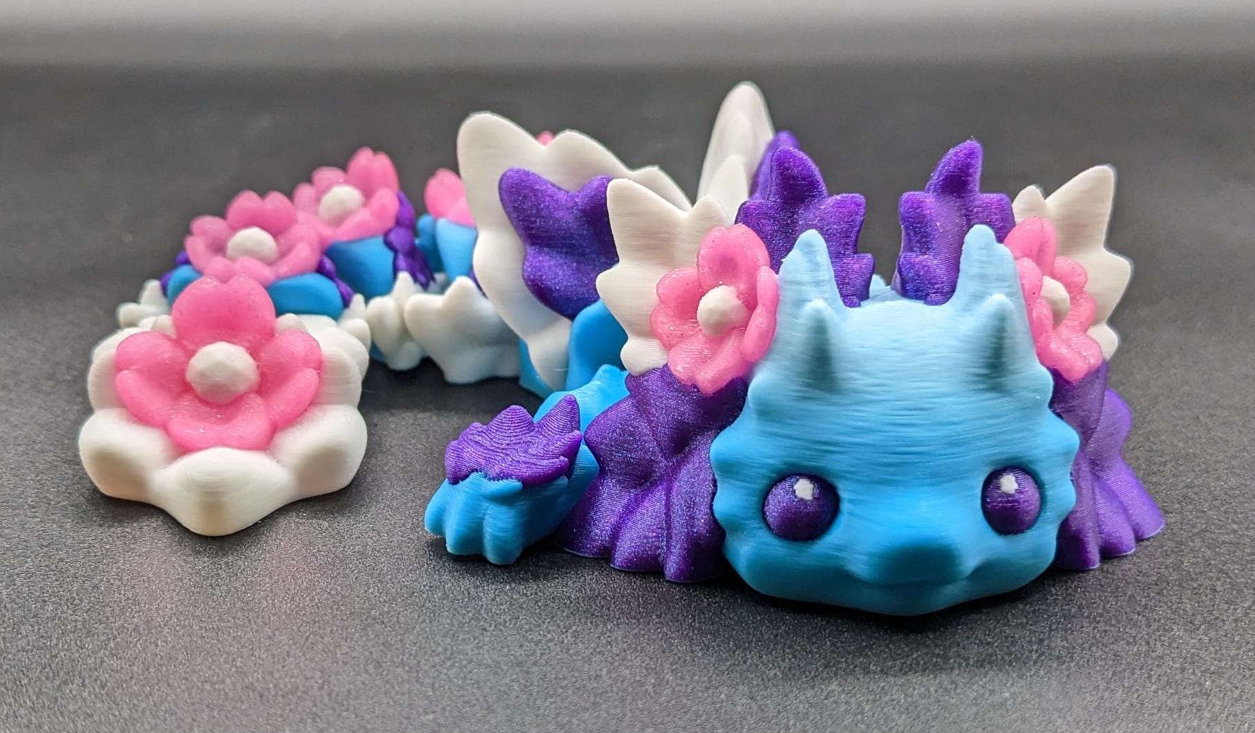 Let the Adorable Baby Kosha Axolotl Flower Dragon bring joy, relaxation, & a touch of enchantment into your life! Whether you’re treating yourself or someone special, this charming fidget toy is a delightful combination of fantasy & creativity.