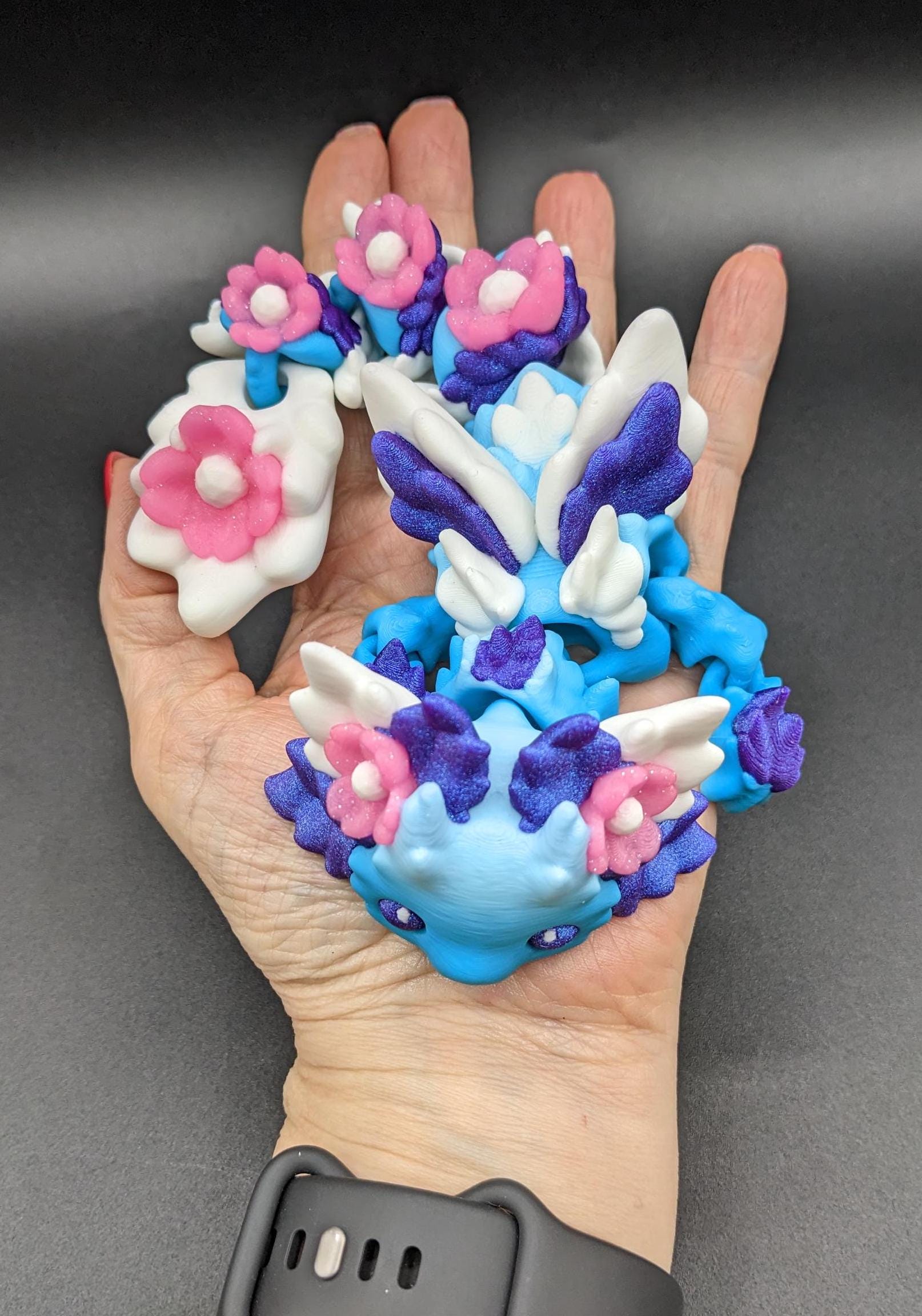 Let the Adorable Baby Kosha Axolotl Flower Dragon bring joy, relaxation, & a touch of enchantment into your life! Whether you’re treating yourself or someone special, this charming fidget toy is a delightful combination of fantasy & creativity.