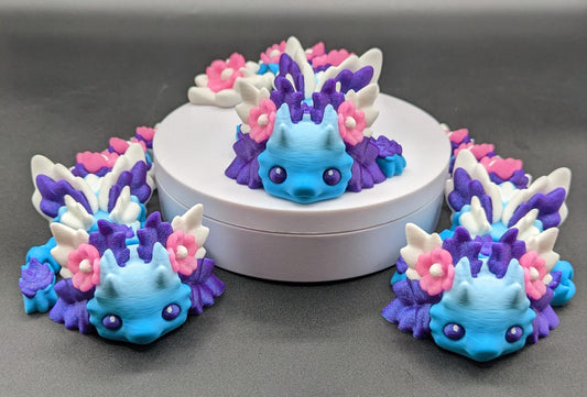 Let the Adorable Baby Kosha Axolotl Flower Dragon bring joy, relaxation, & a touch of enchantment into your life! Whether you’re treating yourself or someone special, this charming fidget toy is a delightful combination of fantasy & creativity.