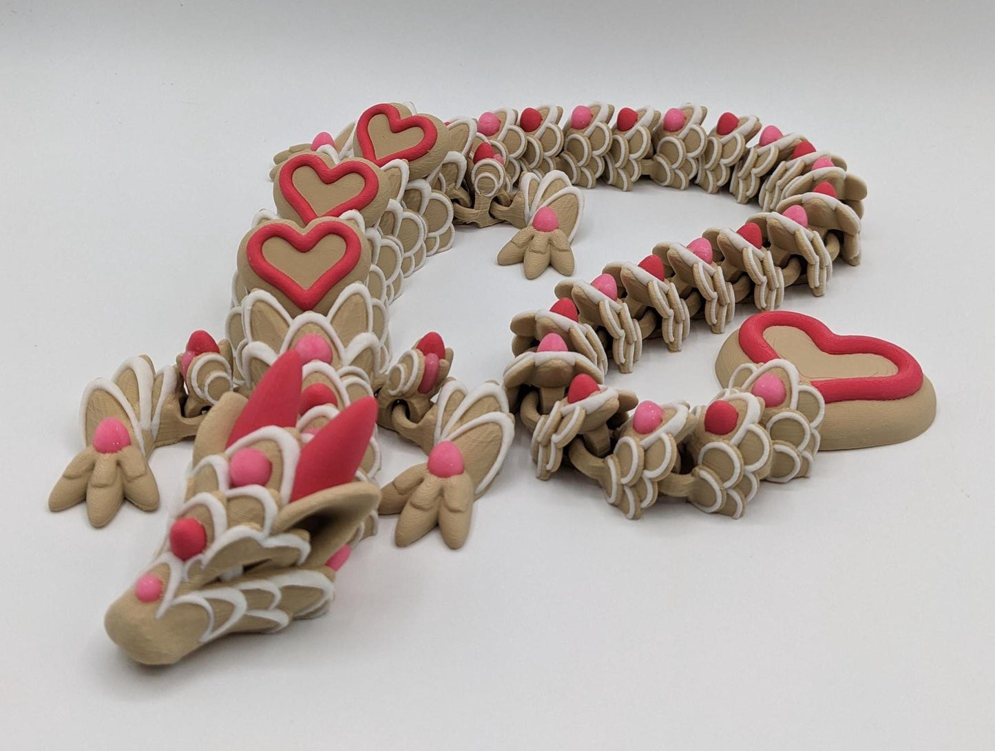 Celebrate love with the Large Articulated Valentineās Heart Cookie Dragon Fidget Toy! This delightful 3D-printed dragon is inspired by the sweetness of cookies & the magic of Valentineās Day, making it the perfect gift for someone you love.