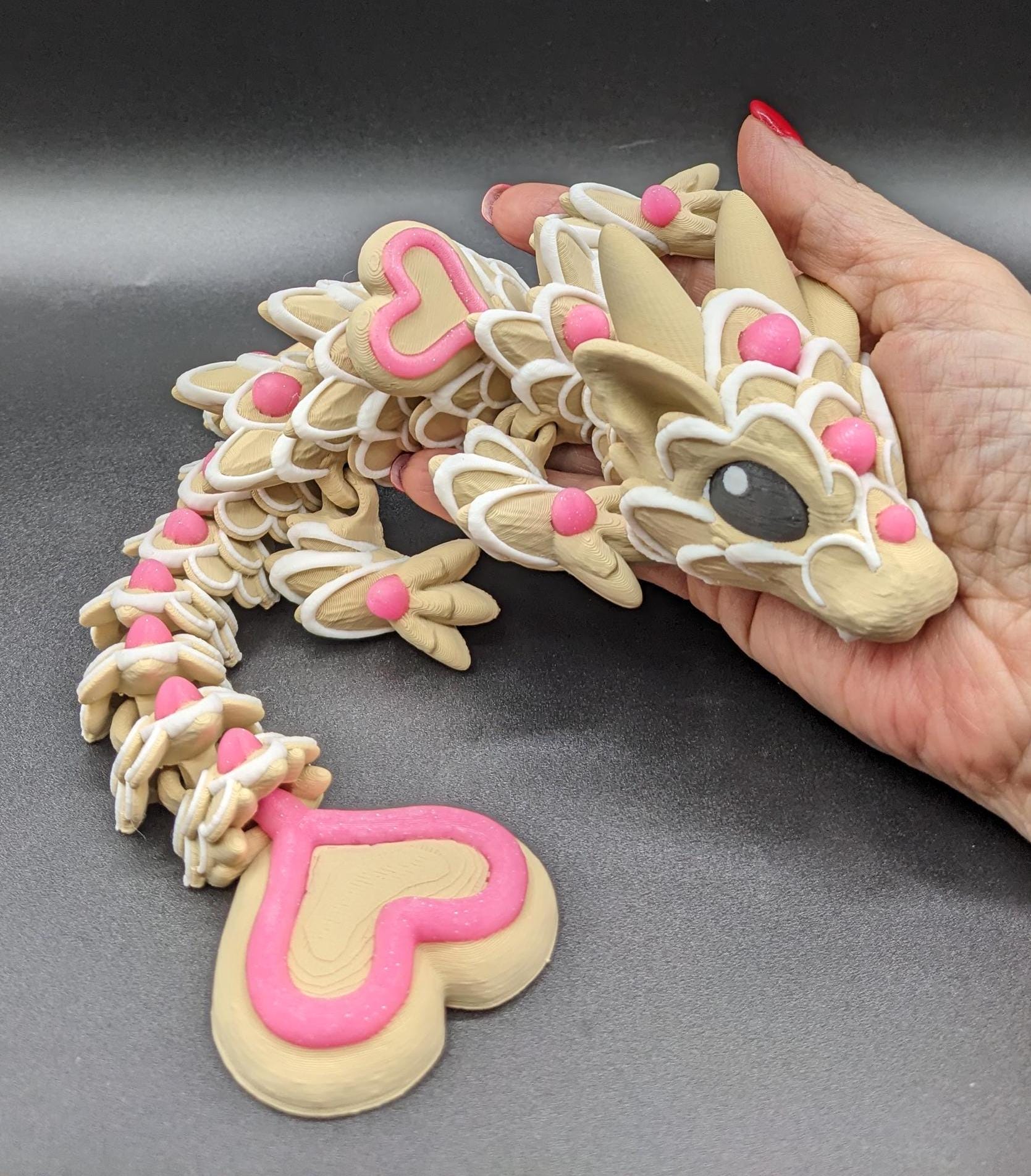 Our adorable 3D-printed dragon combines the whimsical charm of gingerbread cookies, heart-shaped details, & the playful personality of a baby dragon. Whether it’s a holiday gift, an enchanted companion, or a fun fidget toy, this dragon is perfect!