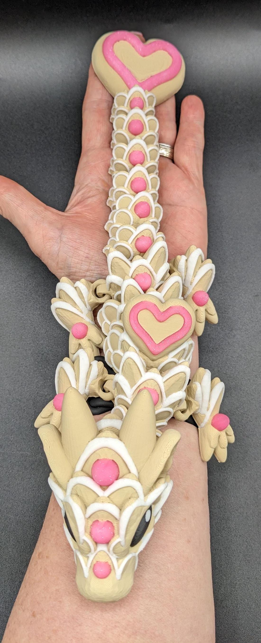 Our adorable 3D-printed dragon combines the whimsical charm of gingerbread cookies, heart-shaped details, & the playful personality of a baby dragon. Whether it’s a holiday gift, an enchanted companion, or a fun fidget toy, this dragon is perfect!