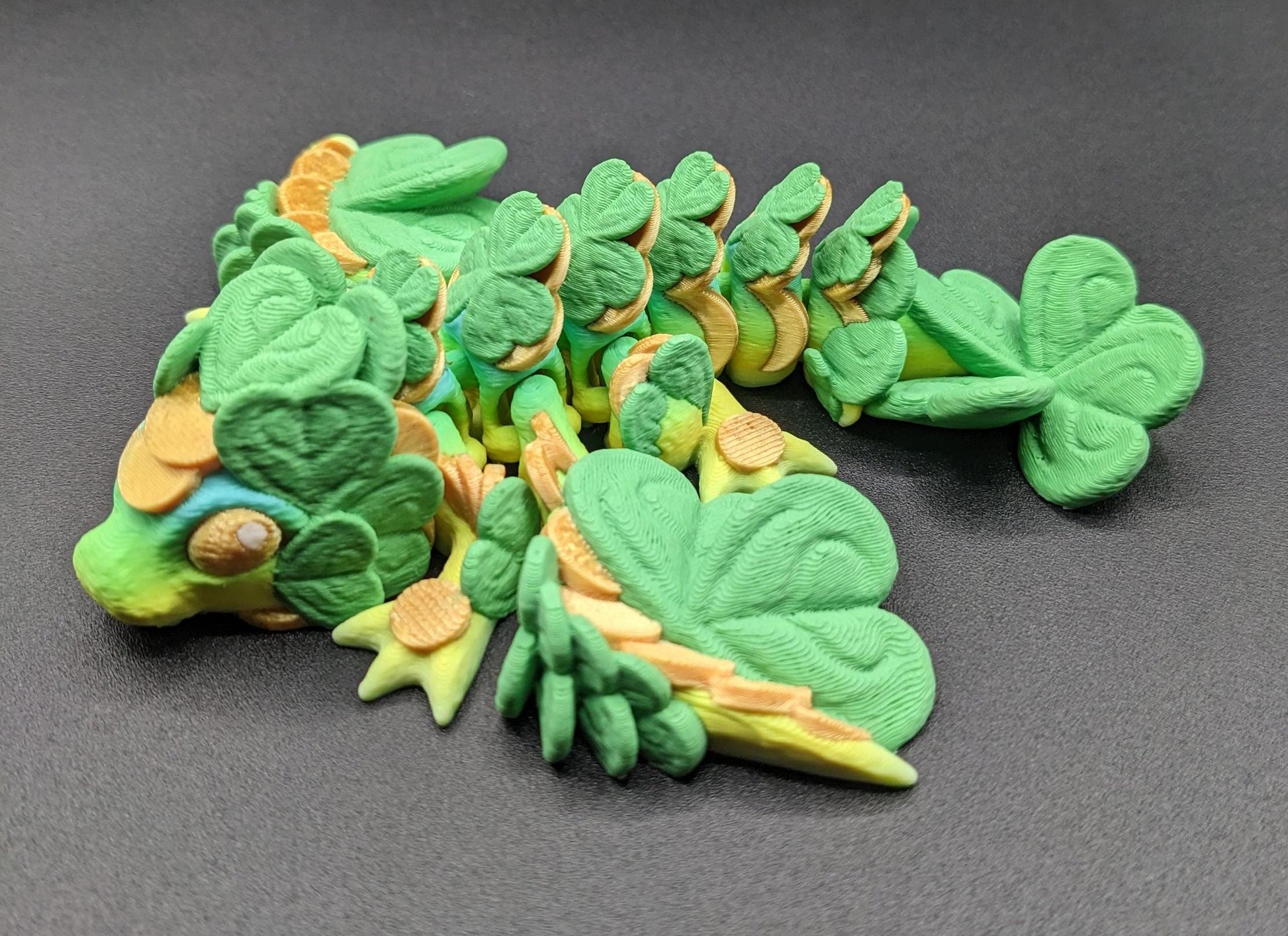 Meet our Adorable Tiny Baby Clover Dragon featuring intricate details & whimsical design, inspired by the luck & charm of clovers. Perfect for dragon enthusiasts or anyone who loves all things small. With the luck of the leprechaun, this little dragon is the perfect lucky charm. Small enough to carry in your pocket or display on desks, shelves, or computer.