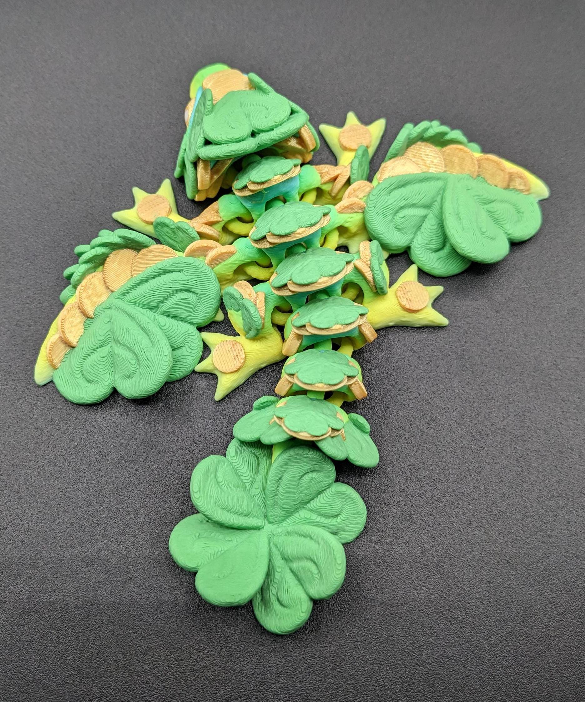 Meet our Adorable Tiny Baby Clover Dragon featuring intricate details & whimsical design, inspired by the luck & charm of clovers. Perfect for dragon enthusiasts or anyone who loves all things small. With the luck of the leprechaun, this little dragon is the perfect lucky charm. Small enough to carry in your pocket or display on desks, shelves, or computer.