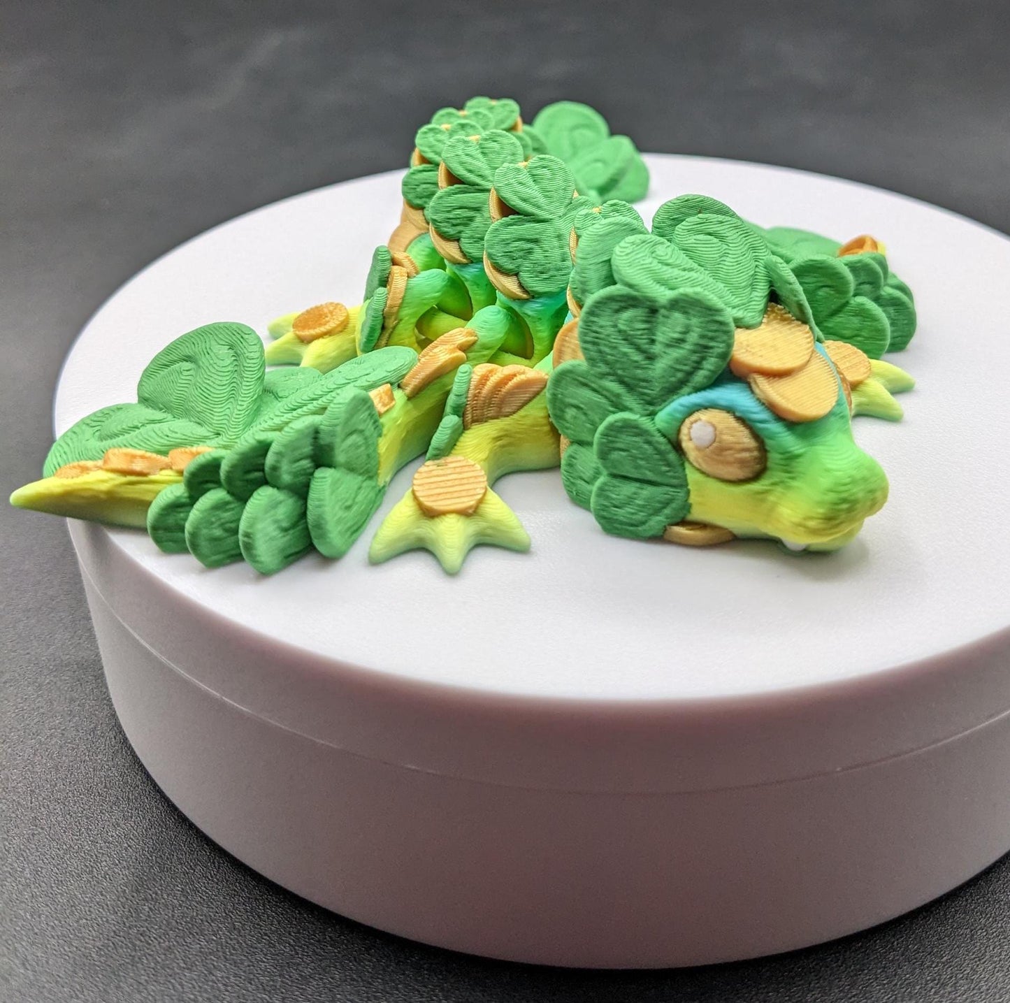 Meet our Adorable Tiny Baby Clover Dragon featuring intricate details & whimsical design, inspired by the luck & charm of clovers. Perfect for dragon enthusiasts or anyone who loves all things small. With the luck of the leprechaun, this little dragon is the perfect lucky charm. Small enough to carry in your pocket or display on desks, shelves, or computer.