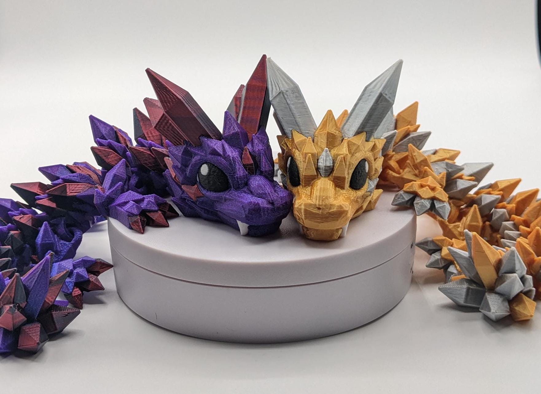 Bring a touch of magic to your life with the Adorable Articulated Baby Crystal Dragon! This 3D-printed masterpiece is designed with intricate details and fully articulated joints, making it a playful and poseable collectible that’s perfect for dragon lovers, fantasy fans, and unique gift seekers. Inspired by the elegance of crystals and the charm of baby dragons, this figurine is both whimsical and eye-catching.