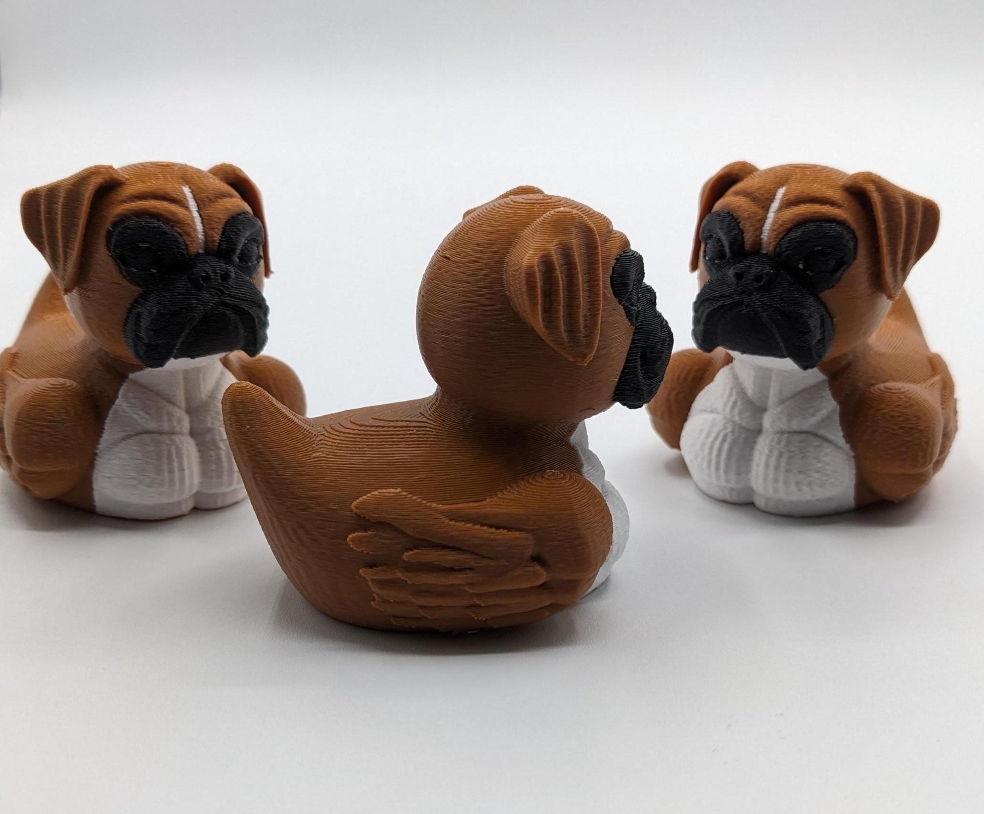 Meet The Magnificent Boxer Duck, a creative and charming 3D-printed hybrid that combines the strong, playful personality of a Boxer dog with the whimsical charm of a duck! This one-of-a-kind figurine is perfect for Boxer lovers, dog enthusiasts, Jeep duck collectors, or anyone who enjoys quirky and imaginative decor. Whether displayed on a shelf, a Jeep dash, added to your collection, or given as a thoughtful gift, this Boxer Duck is guaranteed to bring smiles and brighten up any room.