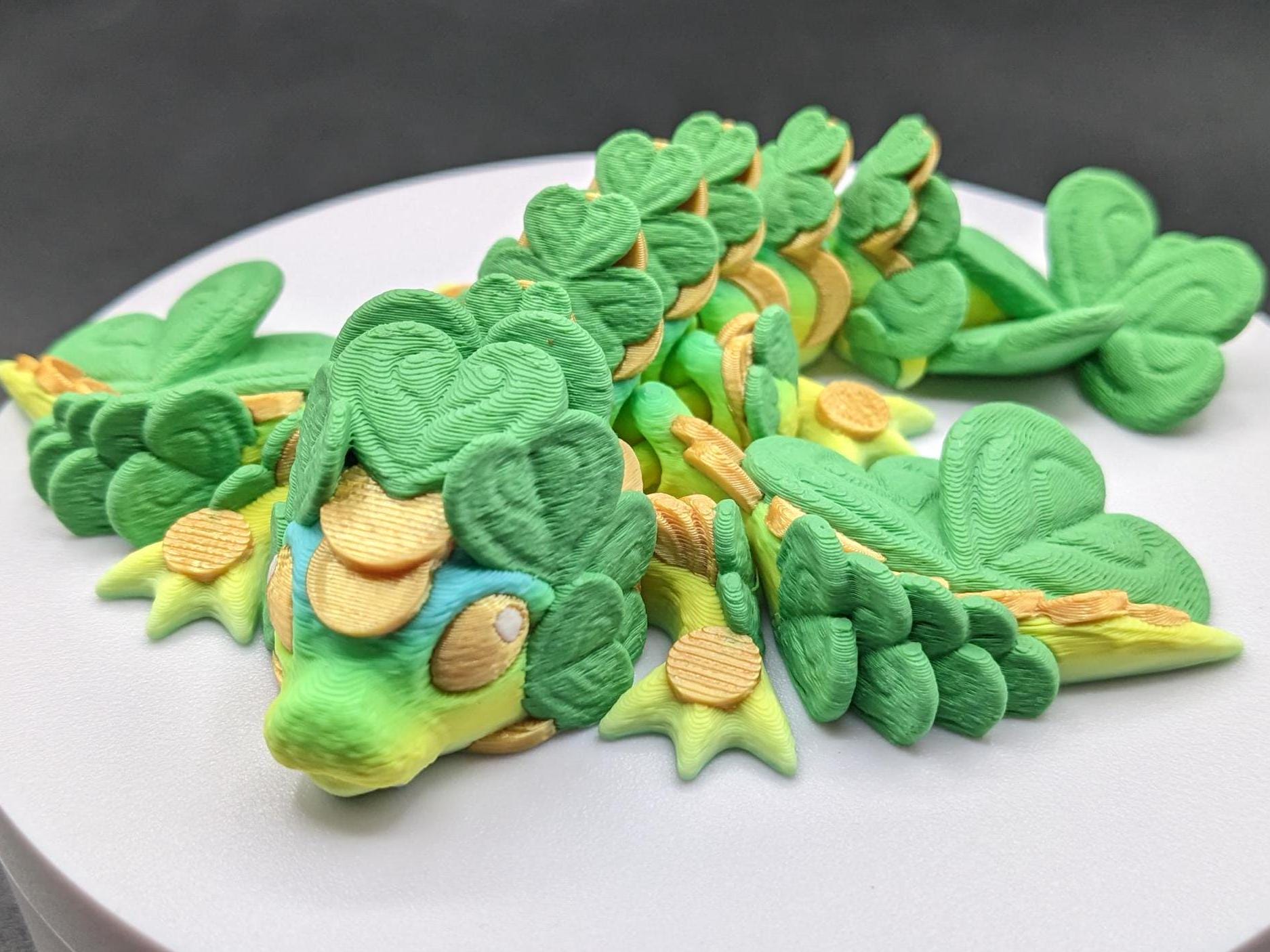 Meet our Adorable Tiny Baby Clover Dragon featuring intricate details & whimsical design, inspired by the luck & charm of clovers. Perfect for dragon enthusiasts or anyone who loves all things small. With the luck of the leprechaun, this little dragon is the perfect lucky charm. Small enough to carry in your pocket or display on desks, shelves, or computer.