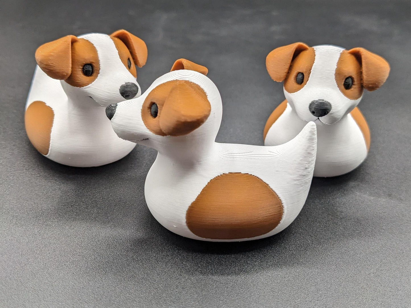 All our ducks are printed in PETG filament, a more expensive filament without the upcharge, as PETG is UV stable, heat and moisture tolerant. PLA color will fade if left on the dash of a car or in direct sunlight. Say hello to the Friendly Jack Russell Terrier Dog Duck Toy, the perfect blend of playful charm and quirky creativity! Whether you’re a dog lover, a Jeep duck collector, or simply someone who enjoys unique and fun decor, this adorable hybrid toy is sure to bring a smile to your face.