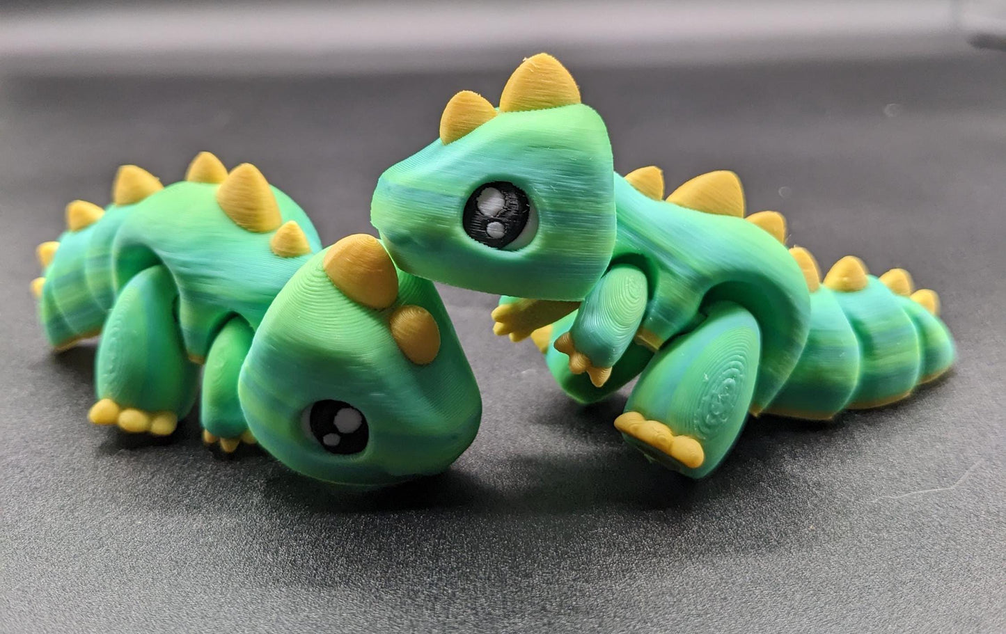 Our Adorable Articulated Baby Trex Flexi Fidget Toy is the perfect pet dinosaur! Our baby Trex  is designed to bring smiles, creativity, & stress relief to your daily routine. Perfect for fidgeting, imaginative play, or as a playful desk companion.