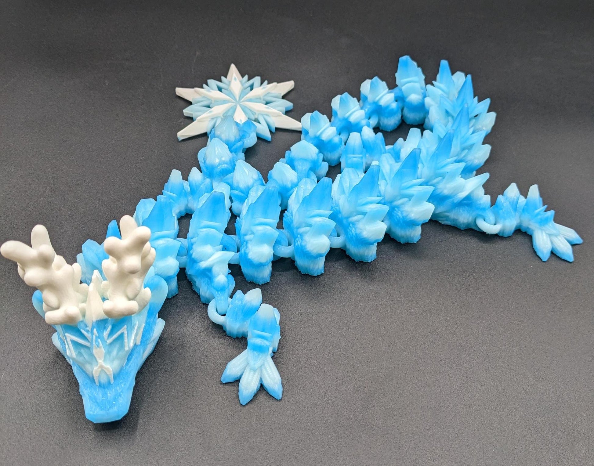 Embrace the wonder of winter with our Articulated Christmas Dragon. This stunning piece features movable joints, allowing you to pose it in various ways, enhancing its majestic presence. Color is icy translucent blue to add to the winter season.