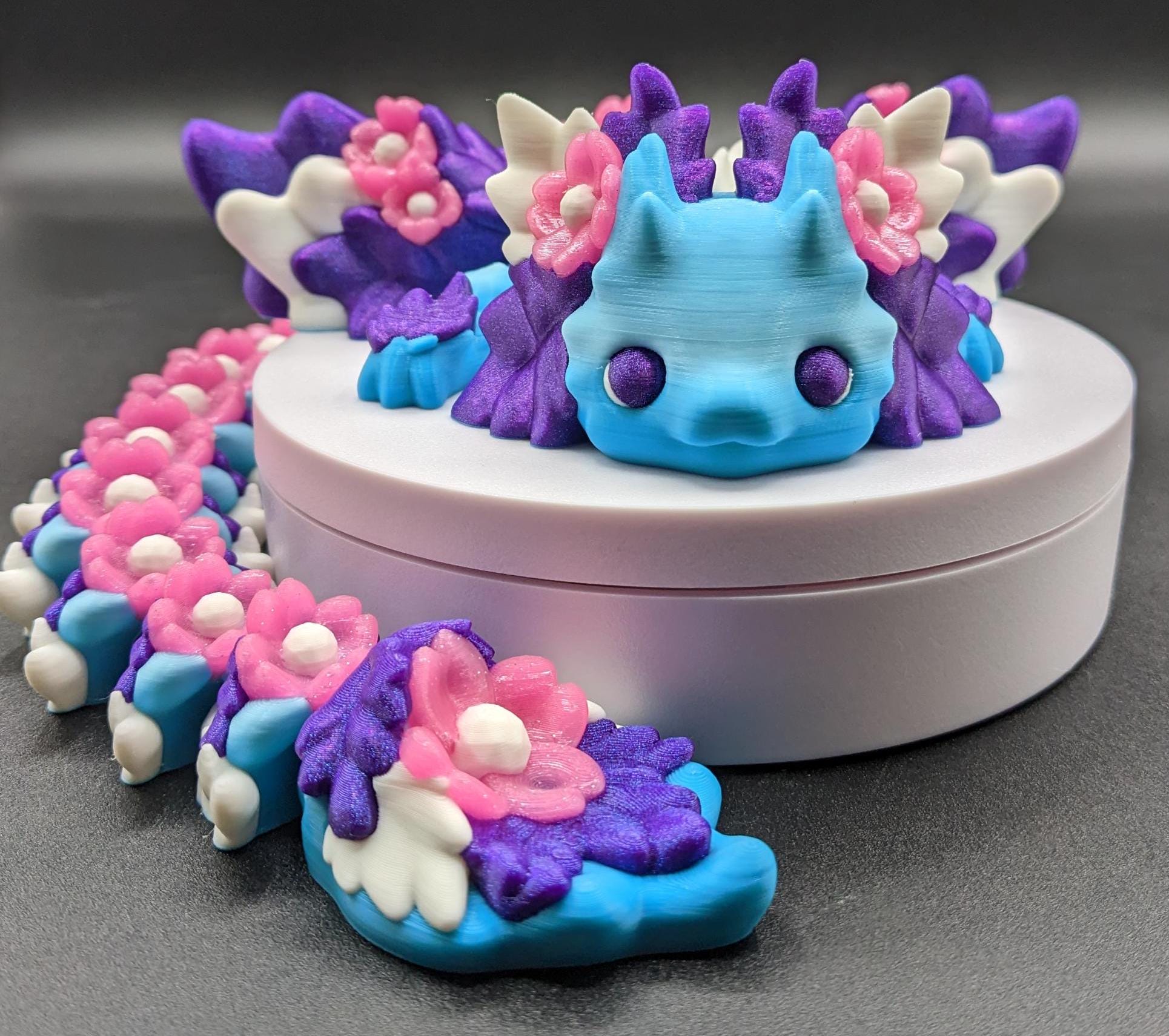 Unleash the magic of the our Beautiful Large Articulated 3D Printed Winged Kosha Axolotl Dragon! This stunning & unique creation combines the whimsical charm of an axolotl with the mythical beauty of a dragon, complete with sparkling wings & flowers.