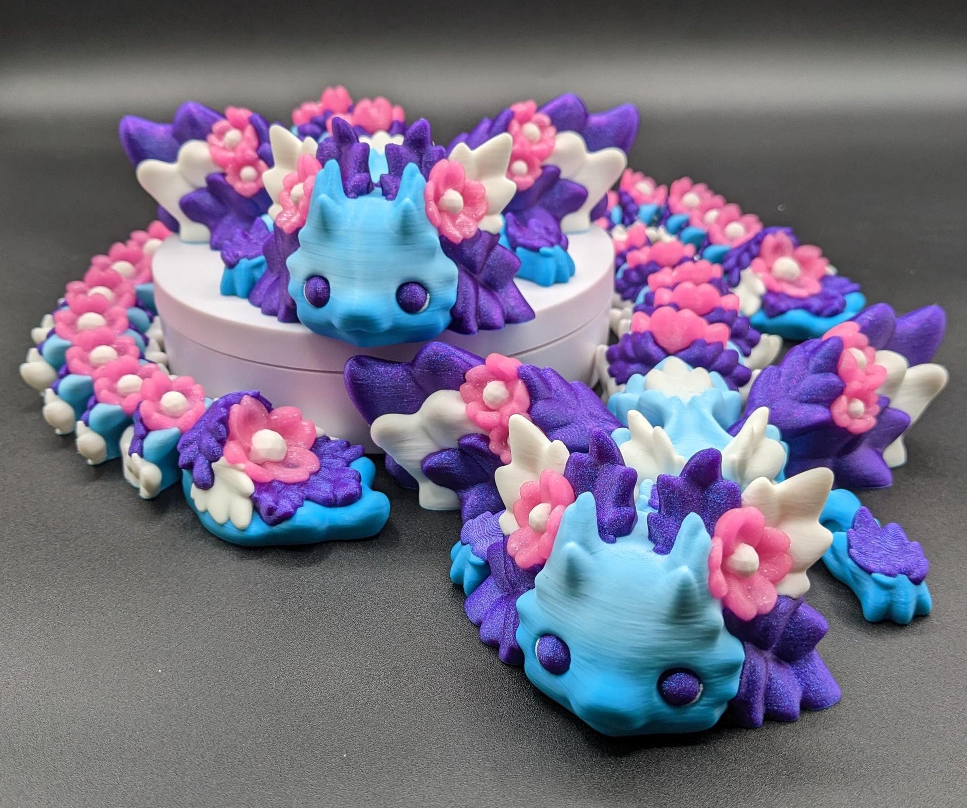Unleash the magic of the our Beautiful Large Articulated 3D Printed Winged Kosha Axolotl Dragon! This stunning & unique creation combines the whimsical charm of an axolotl with the mythical beauty of a dragon, complete with sparkling wings & flowers.