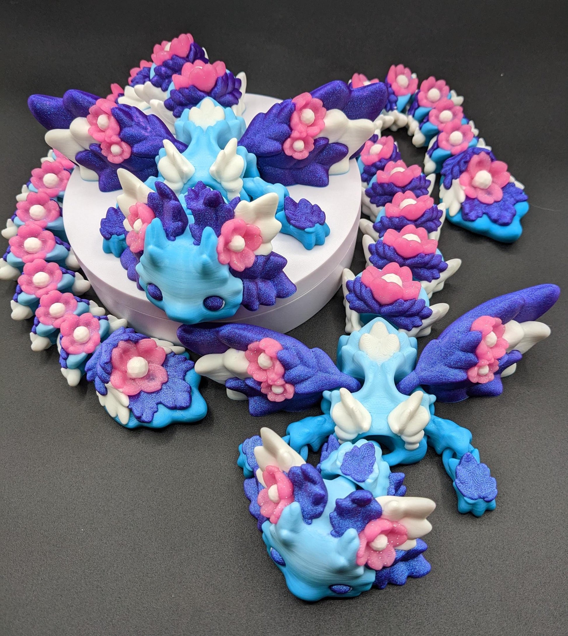 Unleash the magic of the our Beautiful Large Articulated 3D Printed Winged Kosha Axolotl Dragon! This stunning & unique creation combines the whimsical charm of an axolotl with the mythical beauty of a dragon, complete with sparkling wings & flowers.