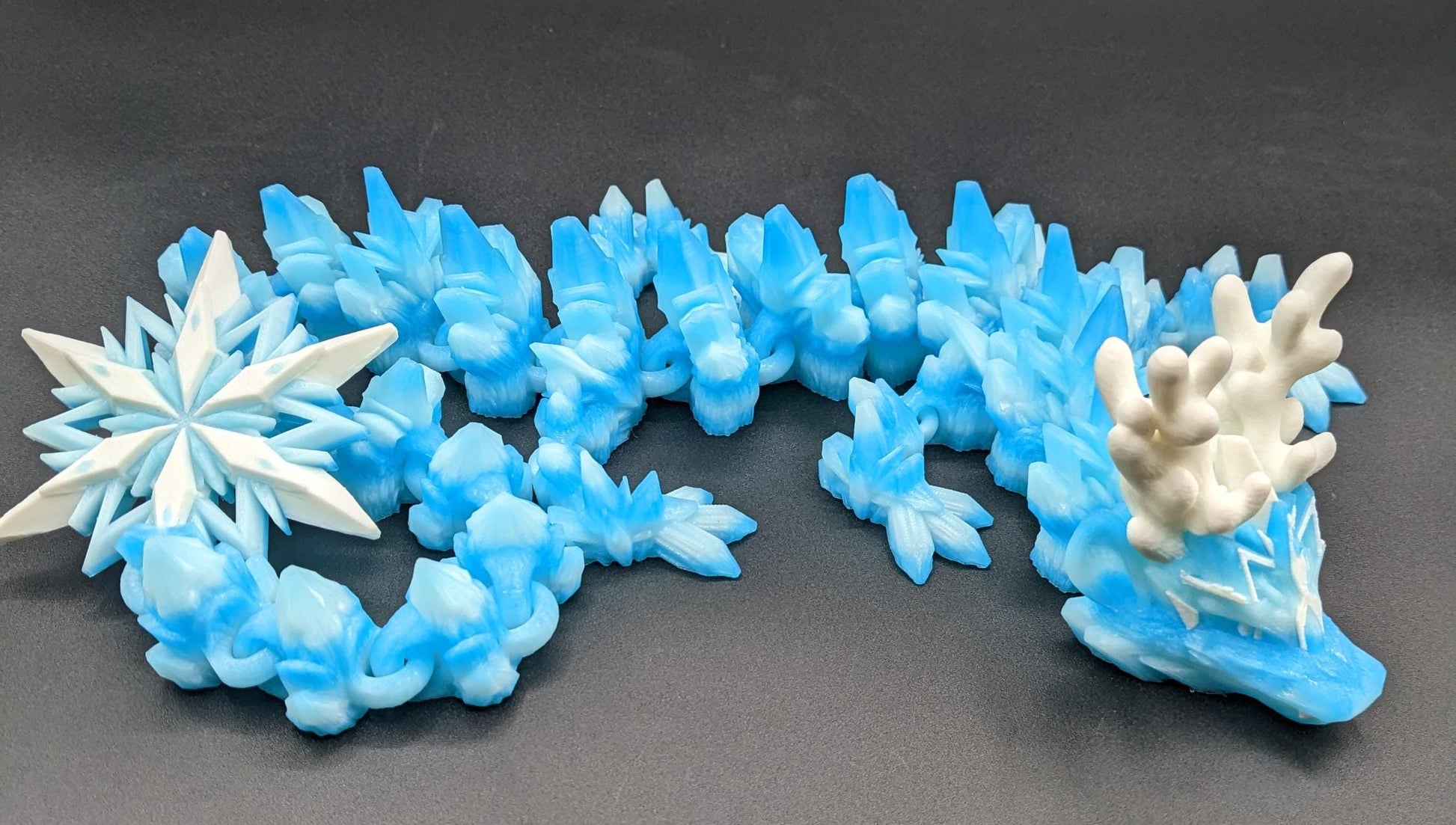 Embrace the wonder of winter with our Articulated Christmas Dragon. This stunning piece features movable joints, allowing you to pose it in various ways, enhancing its majestic presence. Color is icy translucent blue to add to the winter season.