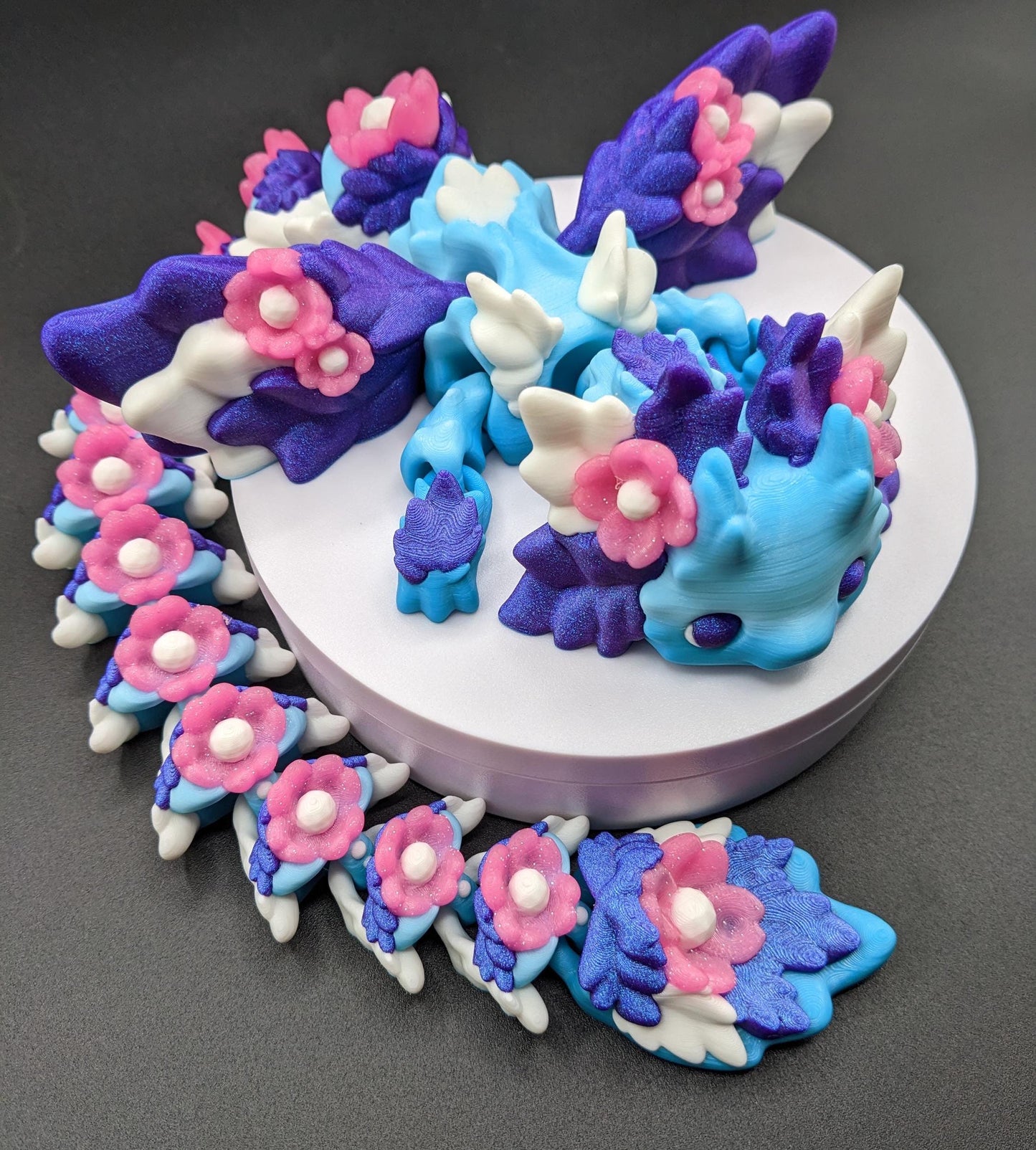 Unleash the magic of the our Beautiful Large Articulated 3D Printed Winged Kosha Axolotl Dragon! This stunning & unique creation combines the whimsical charm of an axolotl with the mythical beauty of a dragon, complete with sparkling wings & flowers.
