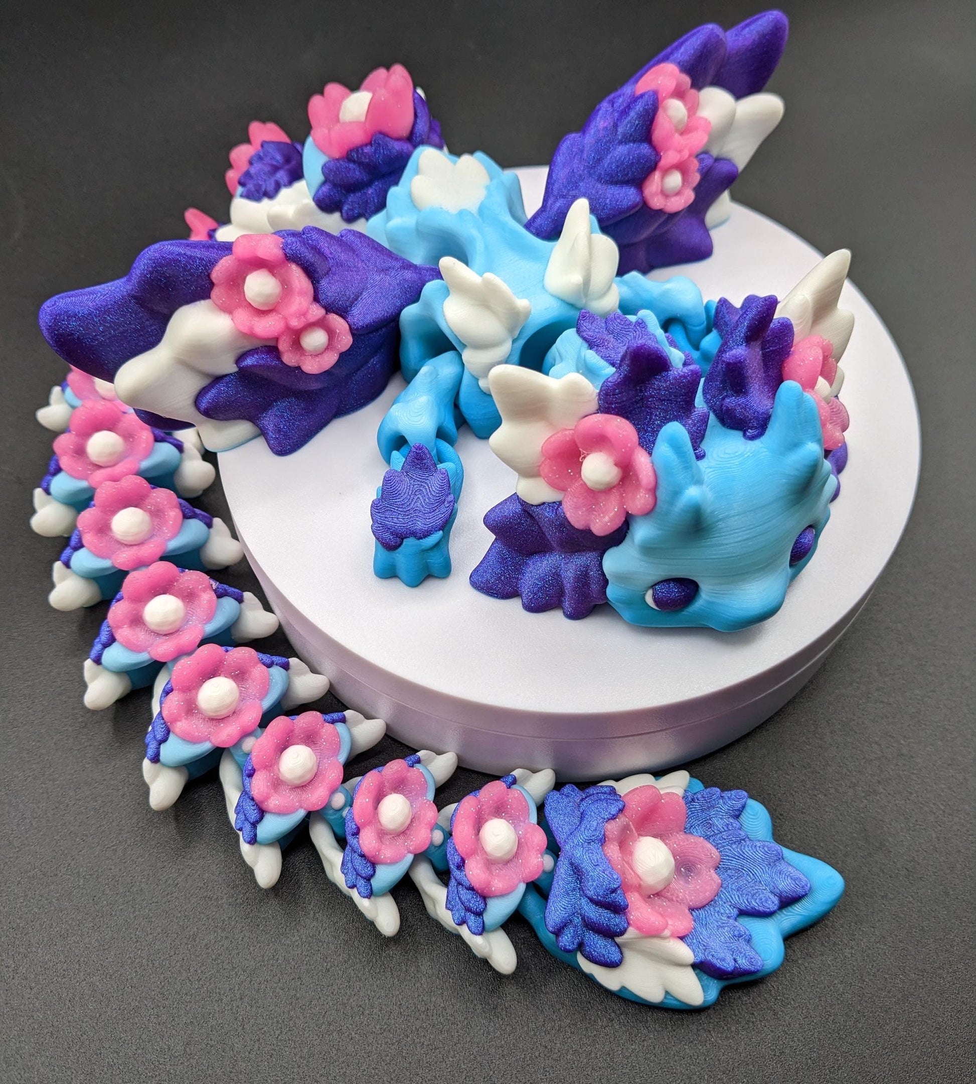 Unleash the magic of the our Beautiful Large Articulated 3D Printed Winged Kosha Axolotl Dragon! This stunning & unique creation combines the whimsical charm of an axolotl with the mythical beauty of a dragon, complete with sparkling wings & flowers.
