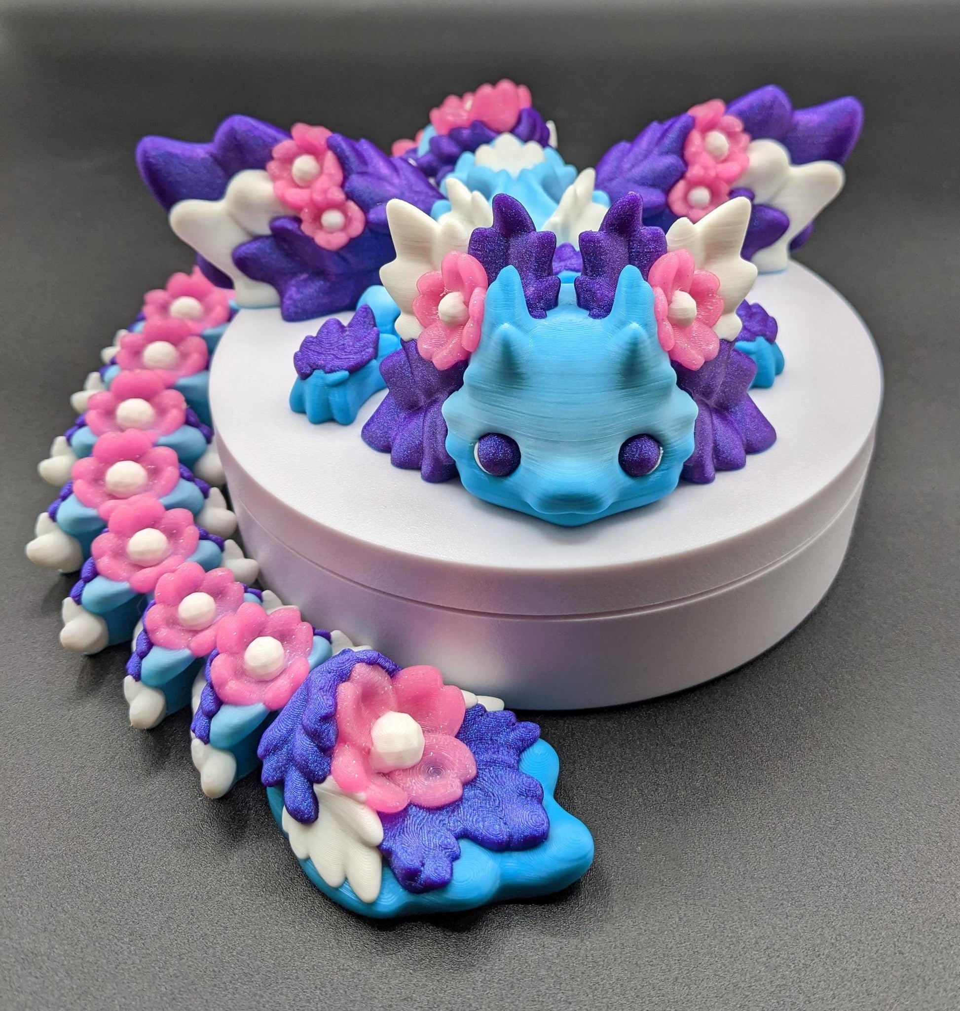 Unleash the magic of the our Beautiful Large Articulated 3D Printed Winged Kosha Axolotl Dragon! This stunning & unique creation combines the whimsical charm of an axolotl with the mythical beauty of a dragon, complete with sparkling wings & flowers.