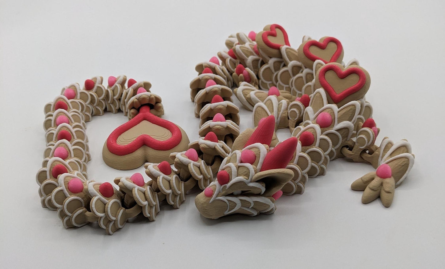 Celebrate love with the Large Articulated Valentine’s Heart Cookie Dragon Fidget Toy! This delightful 3D-printed dragon is inspired by the sweetness of cookies & the magic of Valentine’s Day, making it the perfect gift for someone you love.