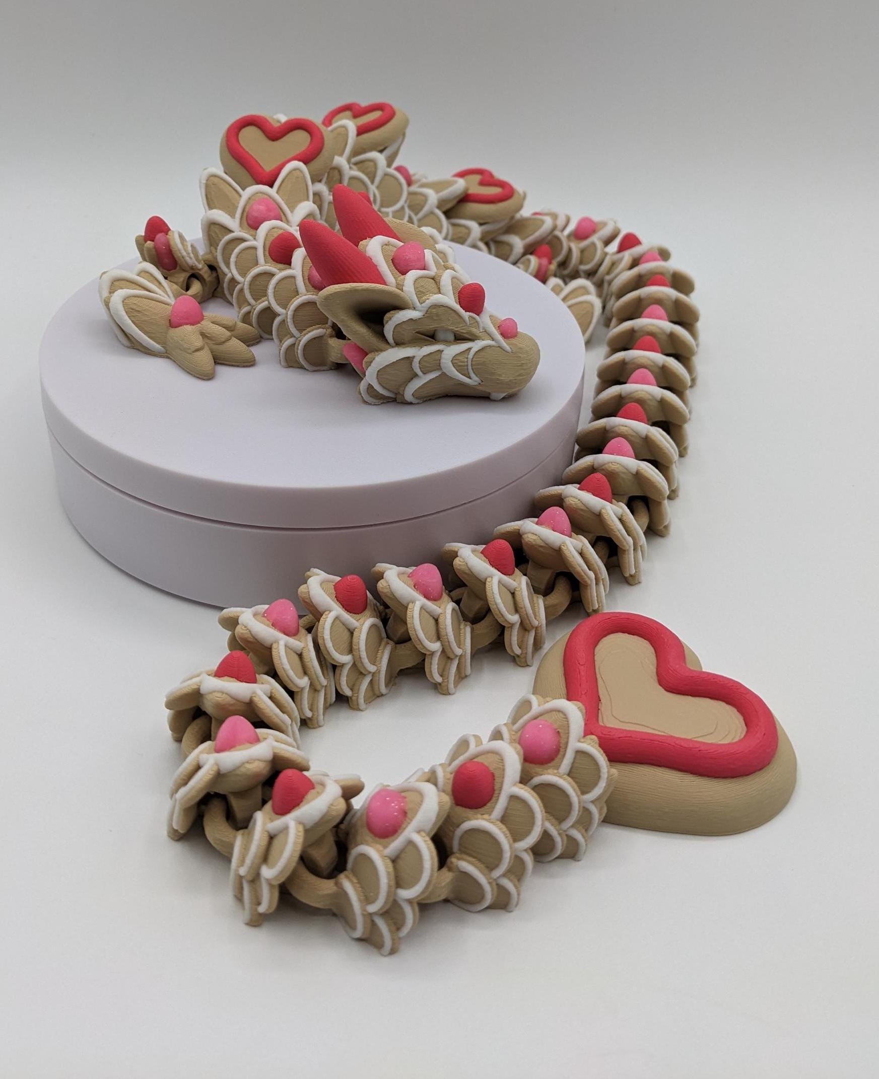 Celebrate love with the Large Articulated Valentine’s Heart Cookie Dragon Fidget Toy! This delightful 3D-printed dragon is inspired by the sweetness of cookies & the magic of Valentine’s Day, making it the perfect gift for someone you love.