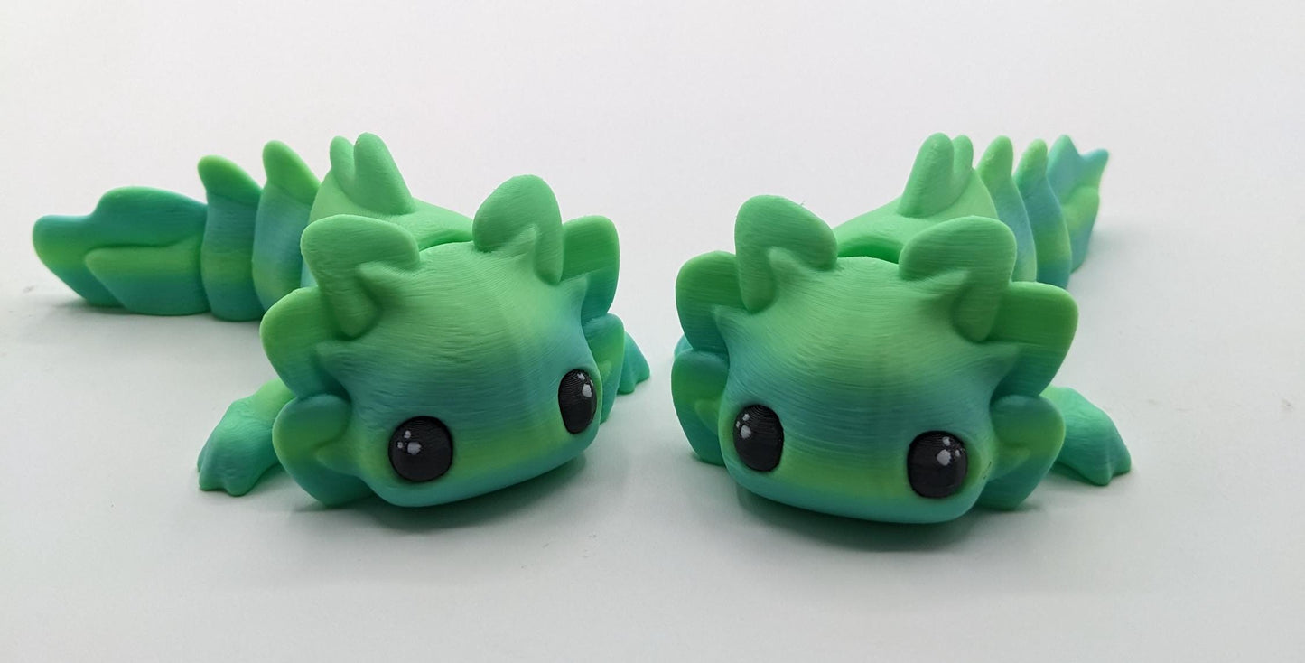 Meet the Adorable Articulated Axolotl Tadpole Fidget Toy, the perfect blend of cuteness and functionality! This 3D-printed axolotl-inspired design features fully articulated joints, making it both fun to fidget with and charming to display.